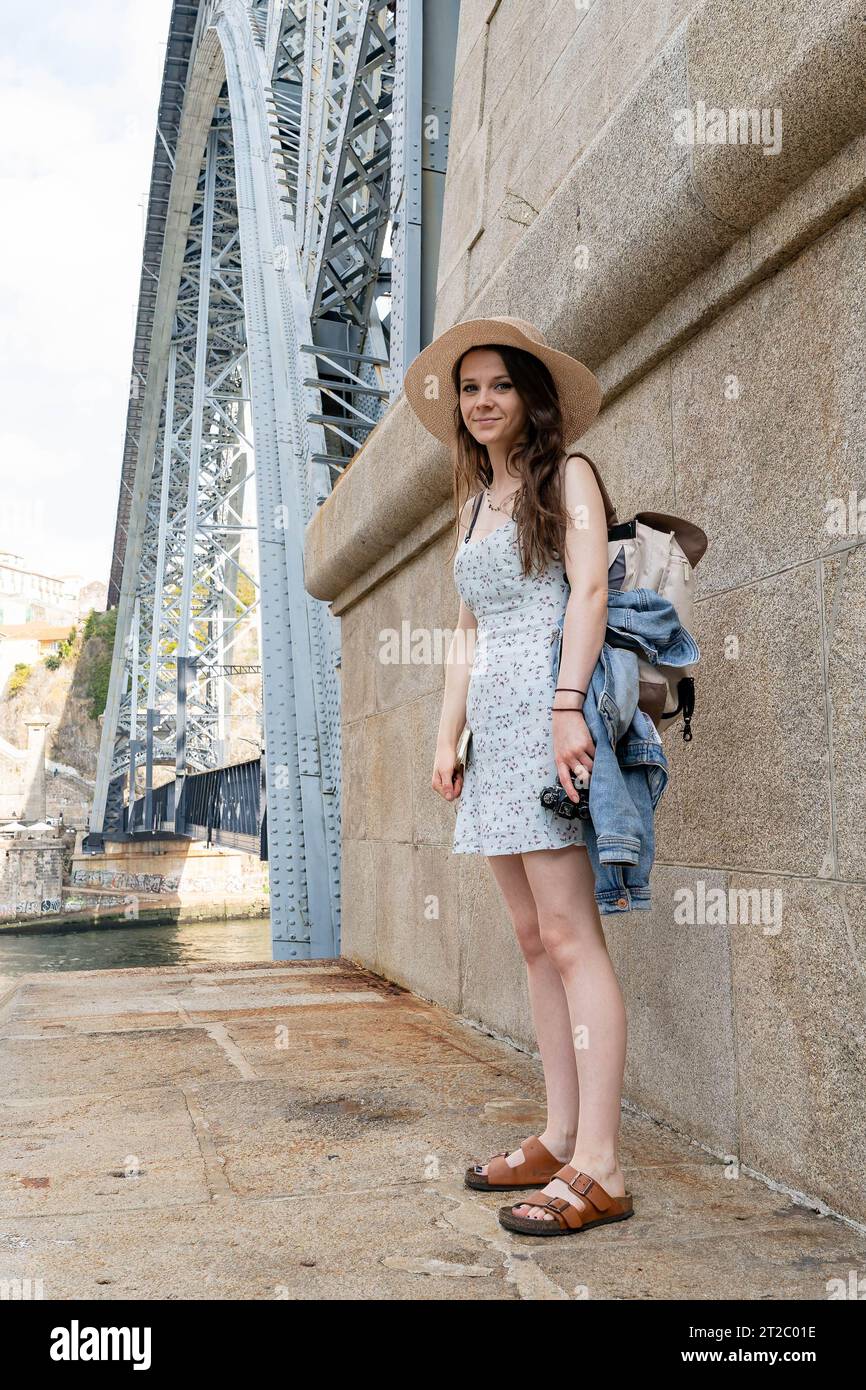 Jeune femme en robe florale explorant le pont historique Banque D'Images