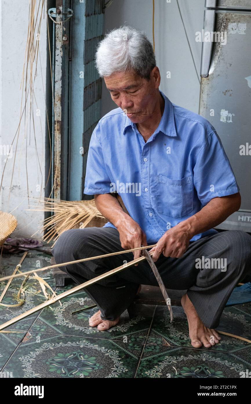 Fendage de bambou pour paniers de tissage, Delta du Mékong, Vietnam Banque D'Images
