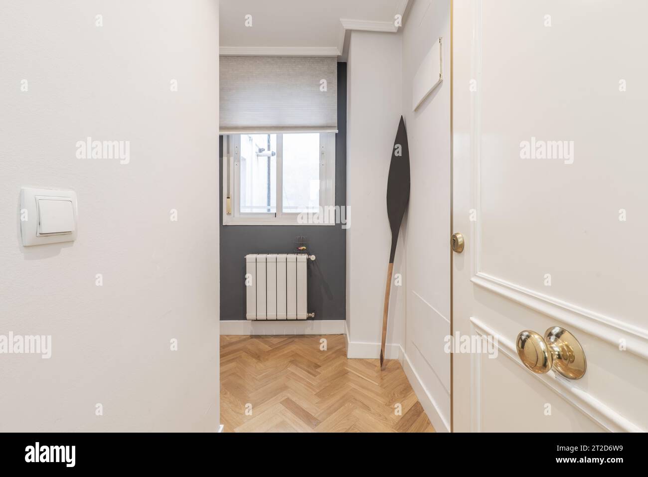 Couloir et couloir d'un appartement résidentiel avec parquet en chêne, fenêtre sur le patio intérieur avec radiateur en aluminium Banque D'Images