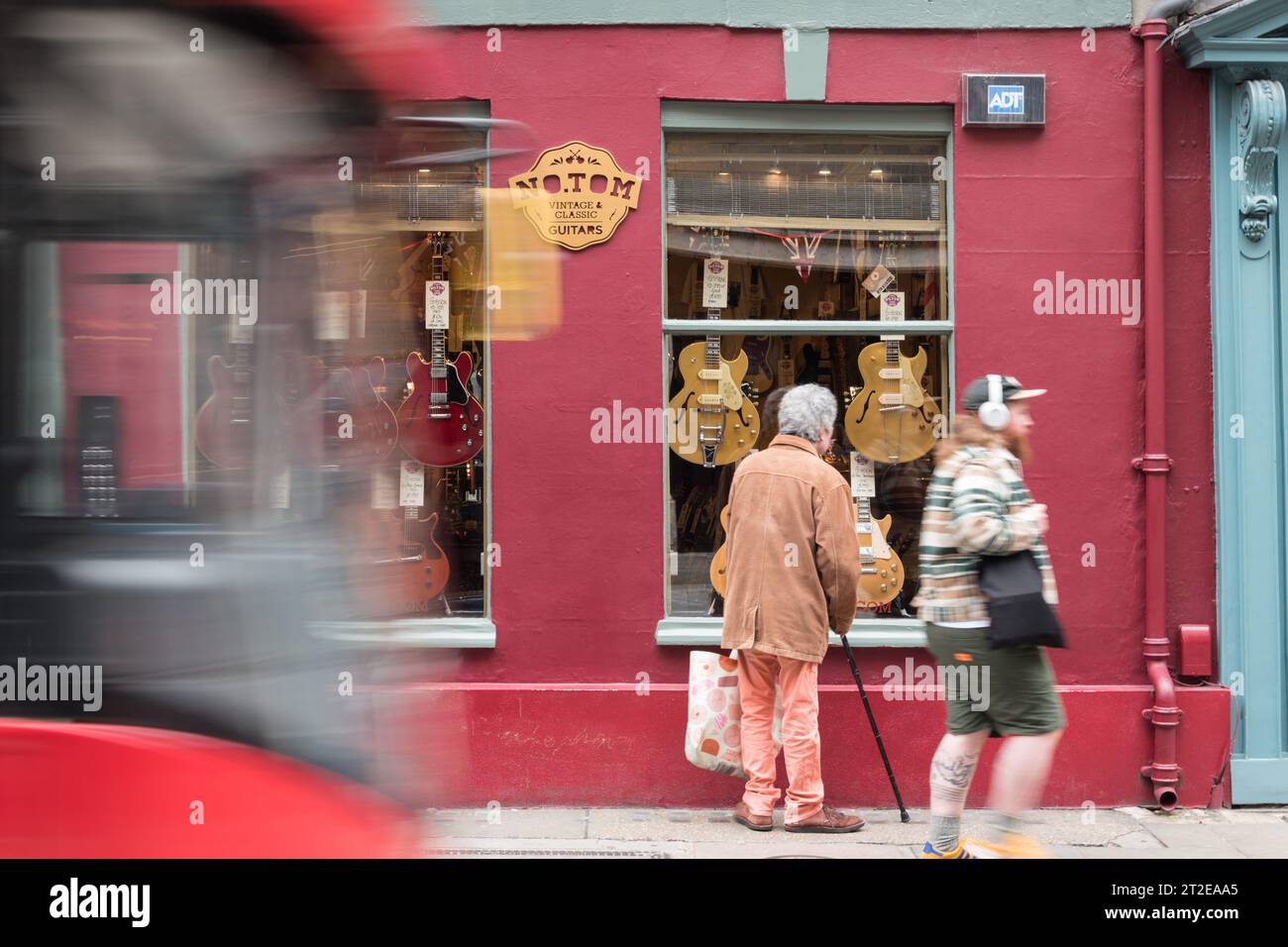 Un homme âgé faisant du lèche-vitrine chez No.Tom Guitars, Denmark Street, Londres, WC2, Angleterre, ROYAUME-UNI Banque D'Images