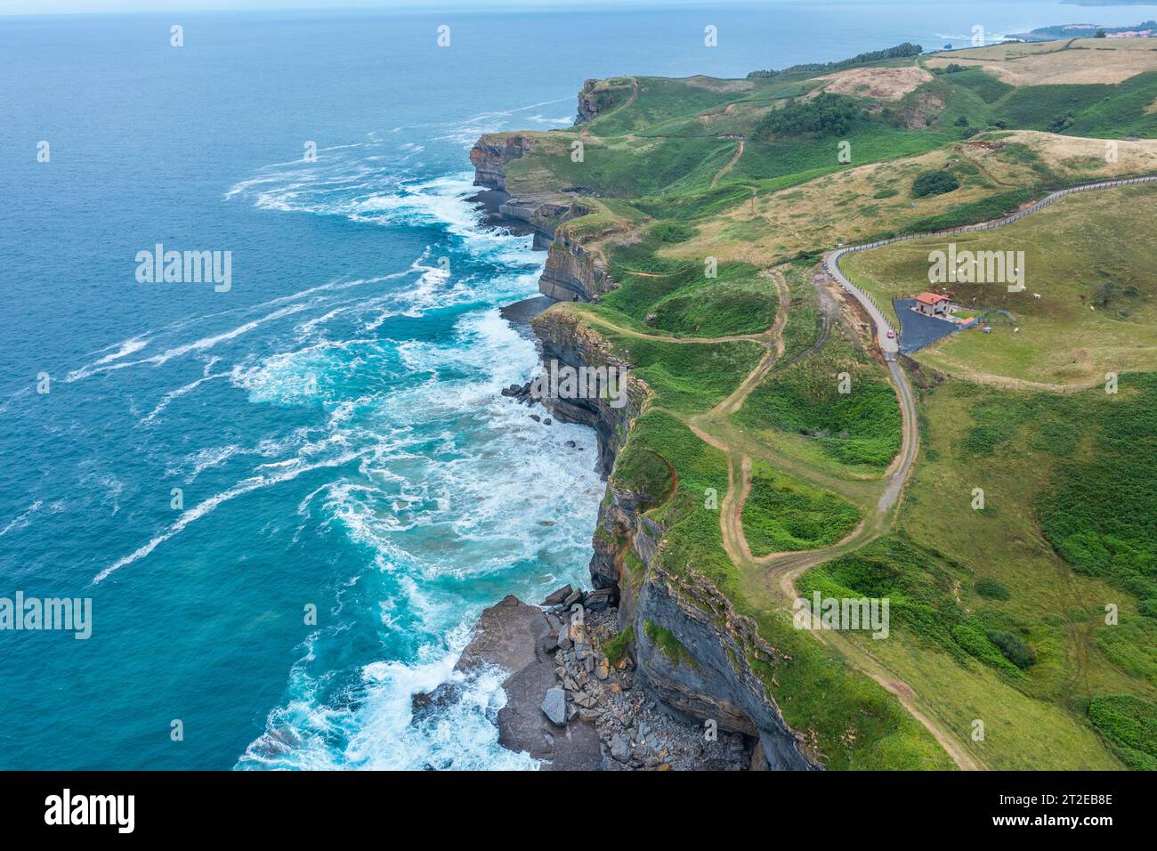 Vue aérienne d'un paysage côtier avec falaises rocheuses et prairies verdoyantes. Cantabrie, Espagne. Banque D'Images