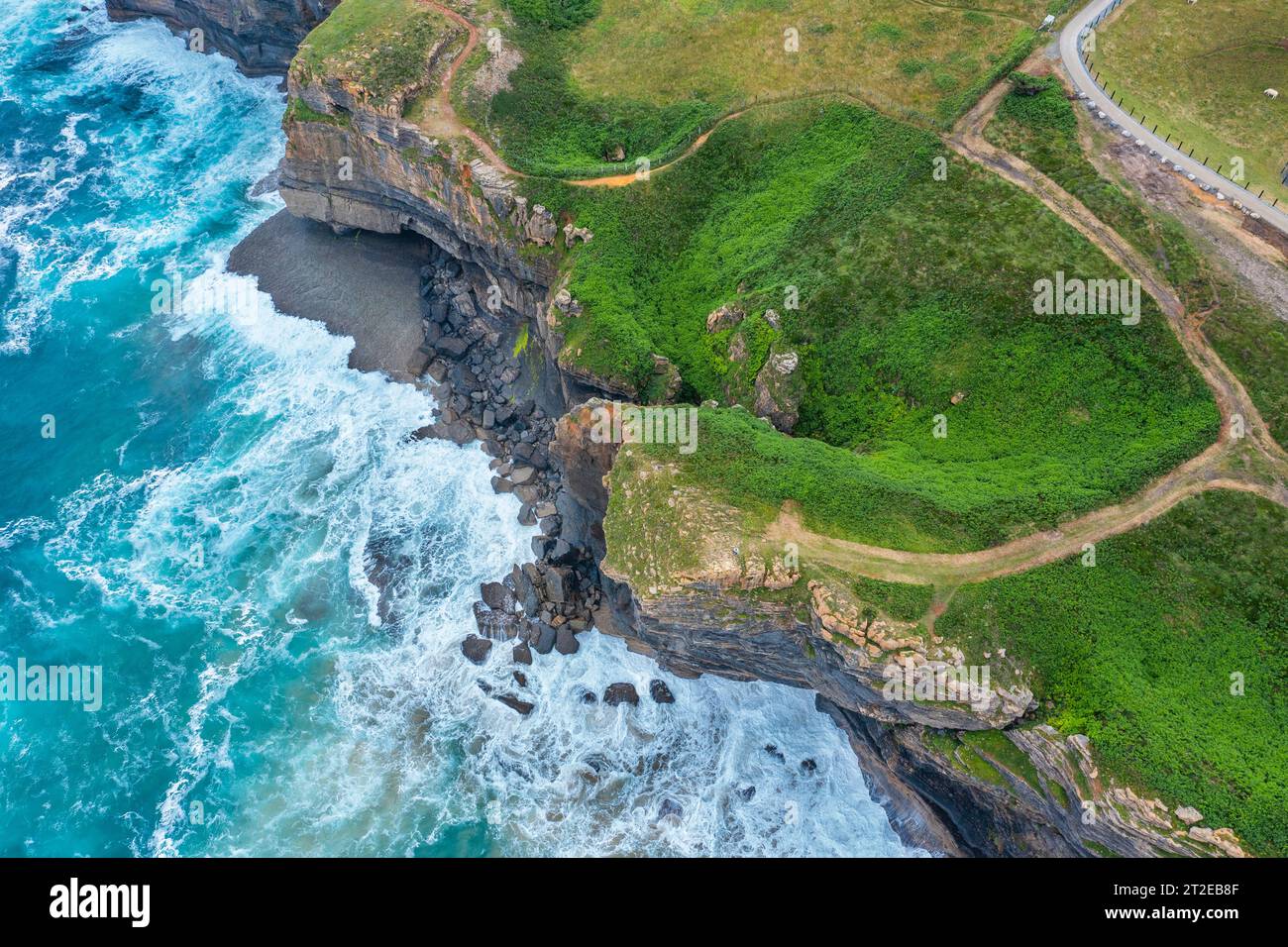 Vue aérienne d'un paysage côtier avec falaises rocheuses et prairies verdoyantes. Cantabrie, Espagne. Banque D'Images