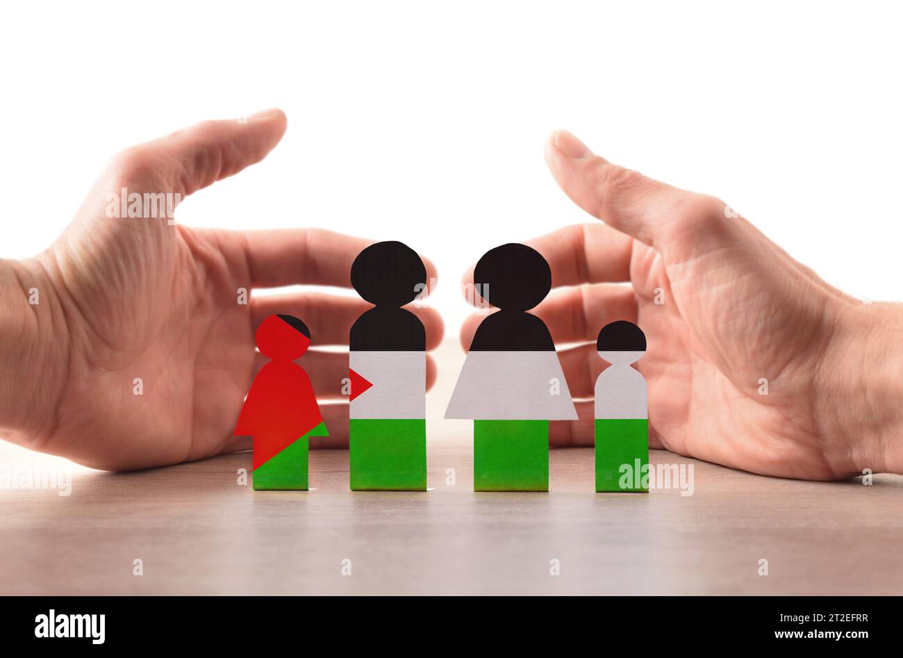 Concept d'aide humanitaire pour les réfugiés de guerre palestiniens avec découpe peinte avec les couleurs du drapeau palestinien sur la table et mains bienvenues behin Banque D'Images