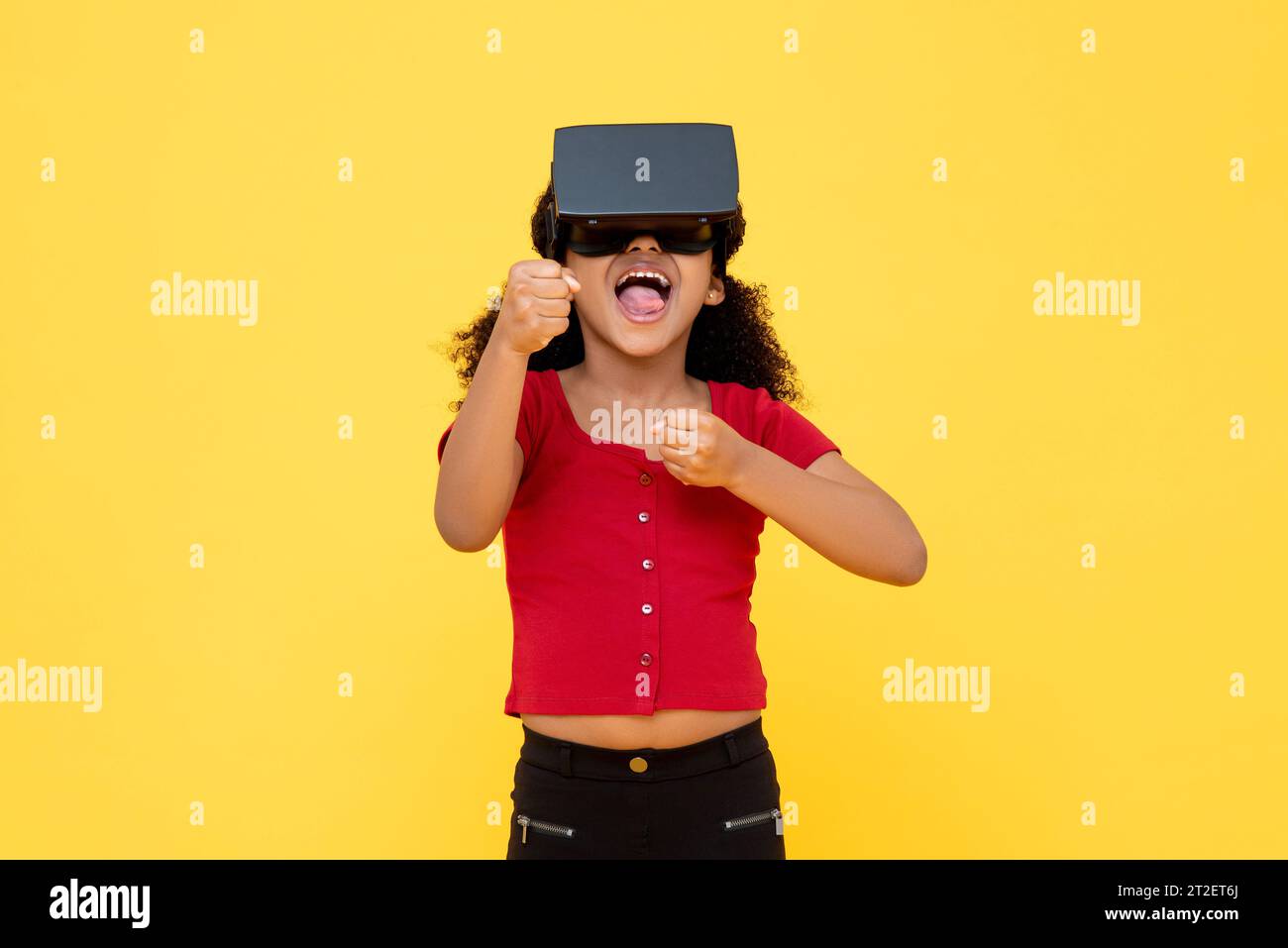 Jeune fille afro-américaine portant du verre VR souriant et jouant dans le fond de couleur jaune photo studio Banque D'Images