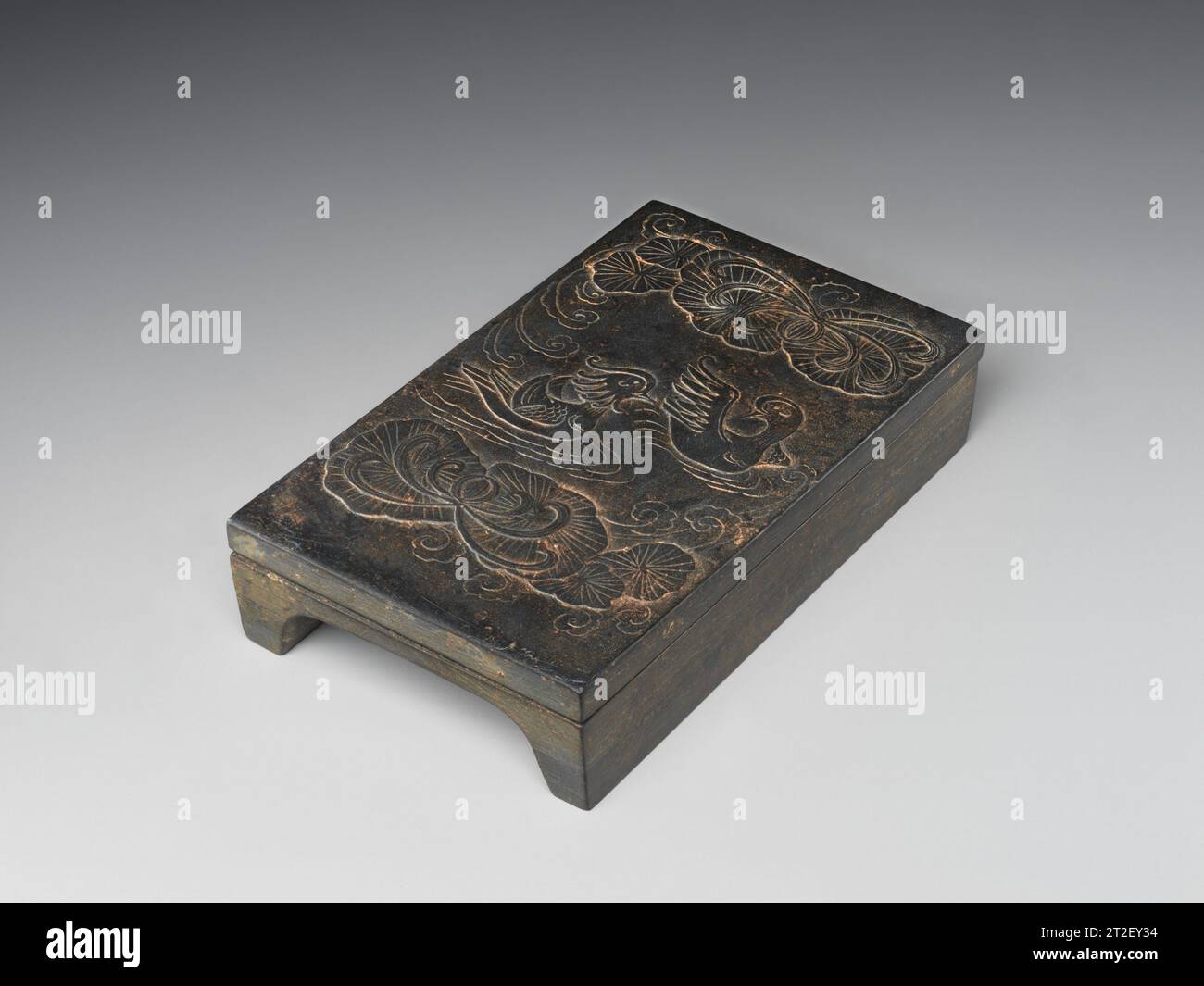 Inkstone et couverture de canards mandarins dans un étang de lotus Chine 11e–12e siècle la forme simple et fonctionnelle de cette œuvre est typique des encres Song literati. Sa couverture est finement sculptée avec une paire de canards mandarins nageant dans un étang de lotus. Les oiseaux de bas-relief et le lotus sont encore animés par des ondulations légèrement gravées et des nuages balayés par le vent. Des motifs similaires trouvés sur les céramiques contemporaines ainsi que sur les métaux en or ou en argent attestent de l'échange important de motifs à travers différents médias à cette époque. Afficher plus. Inkstone et couverture avec des canards mandarins dans un étang de lotus. Chine. 11e–12e ec Banque D'Images