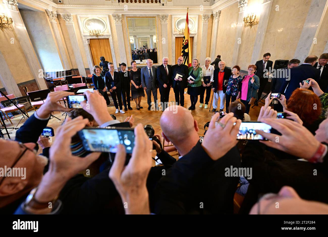 Meiningen, Allemagne. 19 octobre 2023. Le président fédéral Frank-Walter Steinmeier (au centre) se tient aux côtés des lauréats après avoir décerné l'ordre du mérite de la République fédérale d'Allemagne aux citoyens engagés de Thuringe au palais Elisabethenburg. Steinmeier avait déménagé sa résidence officielle à Meiningen pendant trois jours dans le cadre de Ortszeit Deutschland. Les séjours en dehors de Berlin sont destinés à engager une conversation avec les citoyens sur les défis, les souhaits et les préoccupations actuels. Crédit : Martin Schutt/dpa/Alamy Live News Banque D'Images
