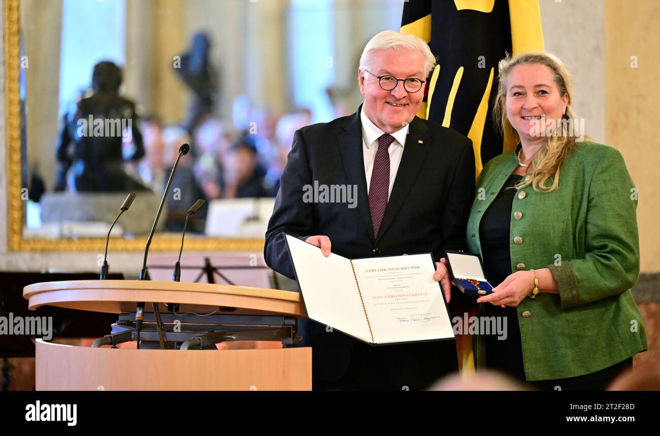 Meiningen, Allemagne. 19 octobre 2023. Le président fédéral Frank-Walter Steinmeier (l) remet à Claudia Geiken de Weimar la Croix du mérite sur ruban lors de la cérémonie de remise de l'ordre du mérite de la République fédérale d'Allemagne aux citoyens engagés de Thuringe au château d'Elisabethenburg. Steinmeier avait déménagé sa résidence officielle à Meiningen pendant trois jours dans le cadre de Ortszeit Deutschland. Les séjours en dehors de Berlin sont conçus pour engager une conversation avec les citoyens sur les défis, les souhaits et les préoccupations actuels. Crédit : Martin Schutt/dpa/Alamy Live News Banque D'Images