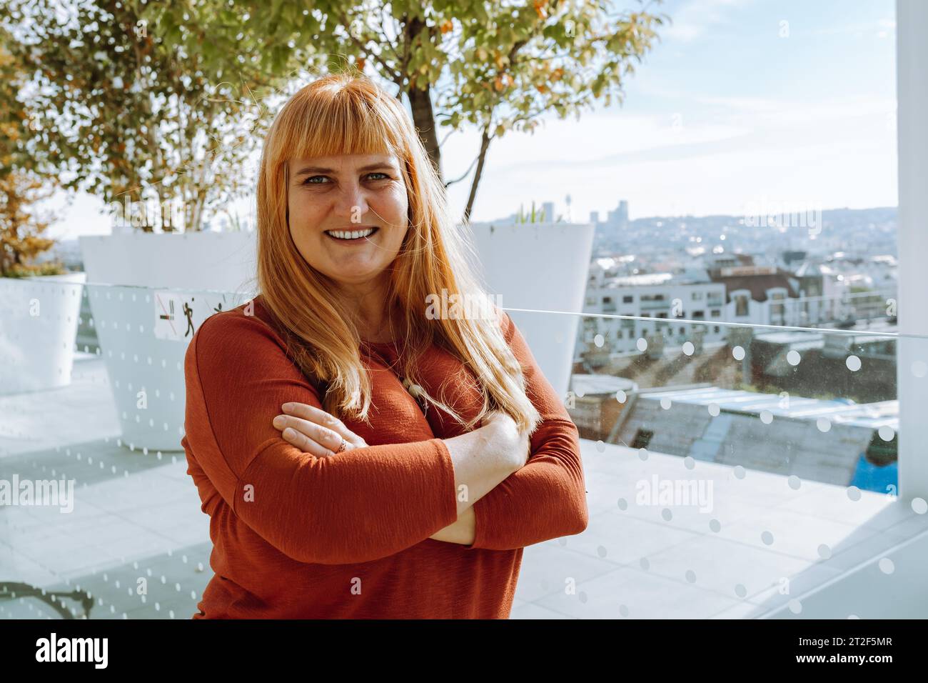 Portrait rouge-cheveux femme d'âge moyen sur fond de paysage urbain flou Banque D'Images