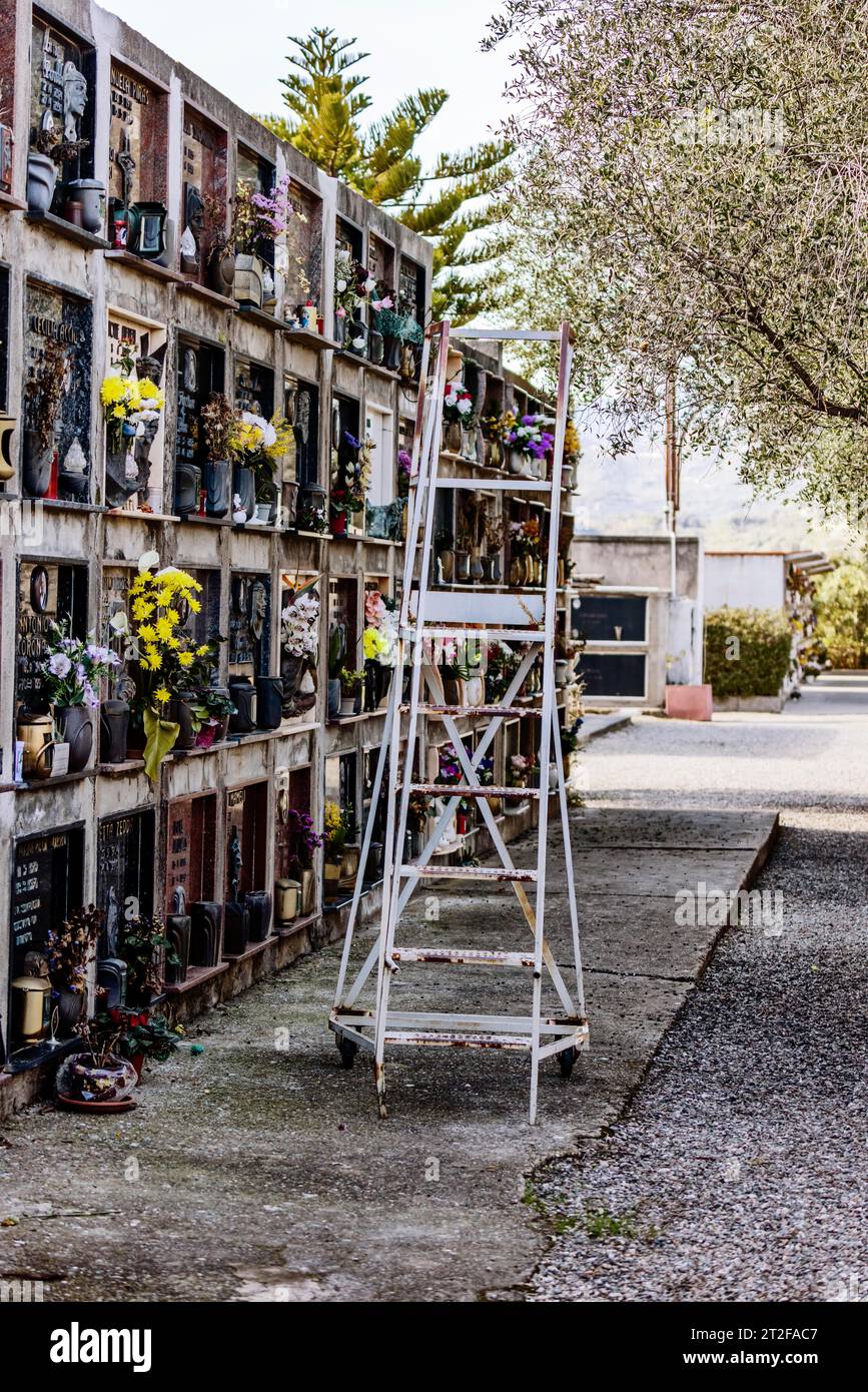 Mur avec tombes et échelle avec roues dans un cimetière, Bari Sardo, Ogliastra, Sardaigne, Italie Banque D'Images