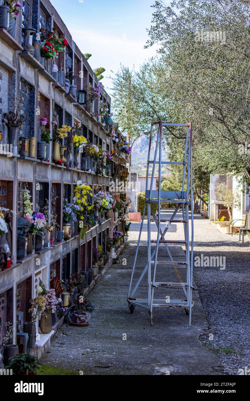 Mur avec tombes et échelle avec roues dans un cimetière, Bari Sardo, Ogliastra, Sardaigne, Italie Banque D'Images