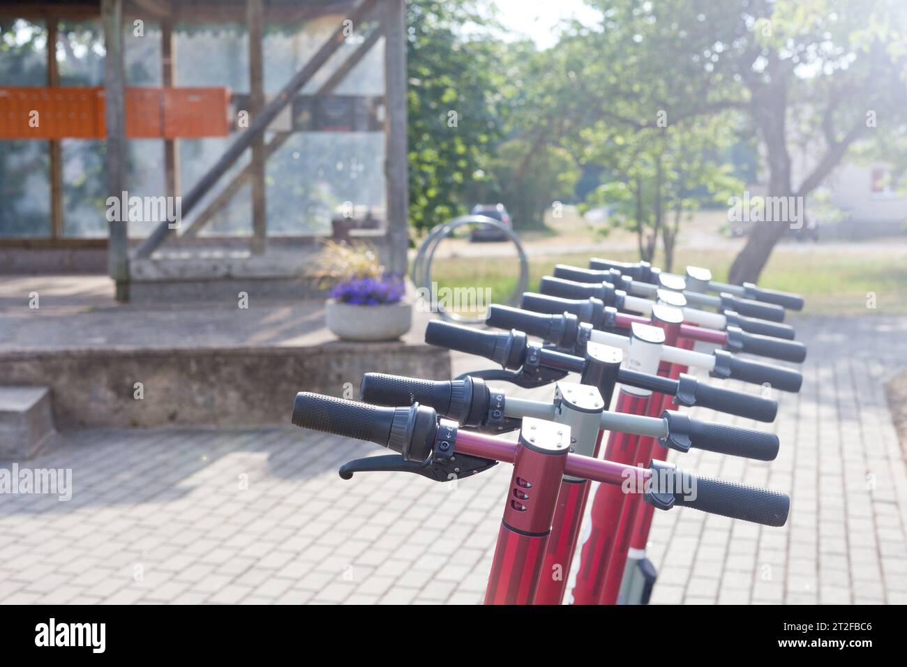 scooter électrique sur place de stationnement. transport urbain - row se prépare à faire du vélo avec des accumulateurs sur le trottoir du parc Banque D'Images