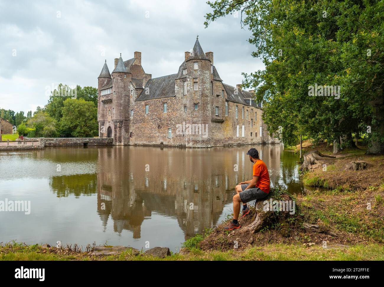 Un jeune homme au bord du lac Château médiéval Trecesson, commune de Campeneac dans le département du Morbihan, près de la forêt de Brocéliande Banque D'Images