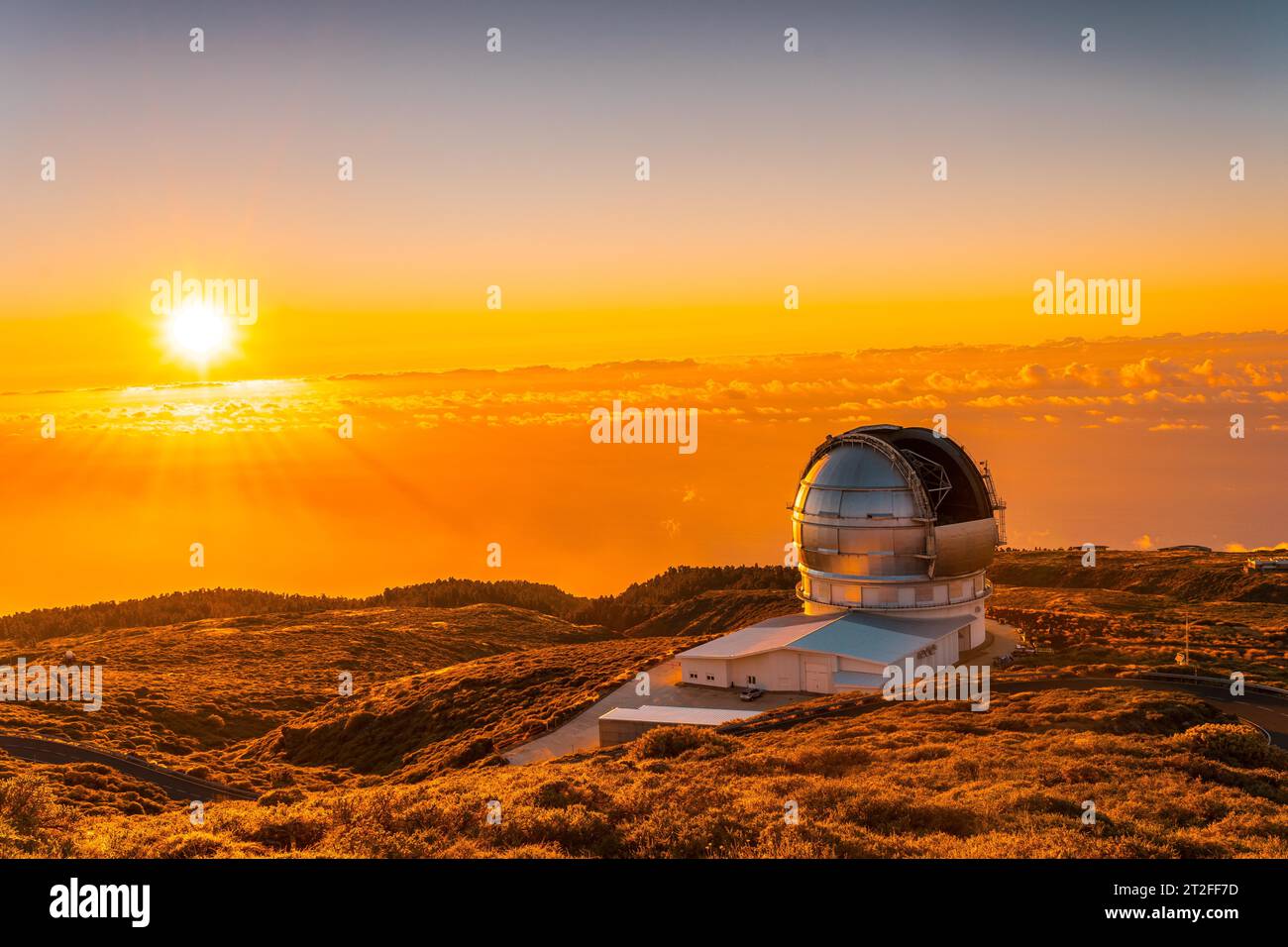 Grand télescope canari appelé Grantecan optico del Roque de los Muchachos dans la Caldera de Taburiente dans un beau coucher de soleil orange, la Palma, Canaries Banque D'Images