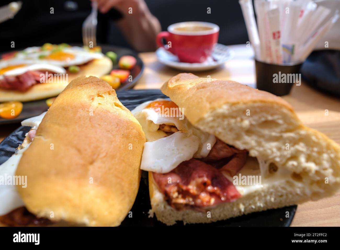 Vue d'un sandwich aux œufs et au bacon et d'une omelette en arrière-plan à iOS Grèce Banque D'Images