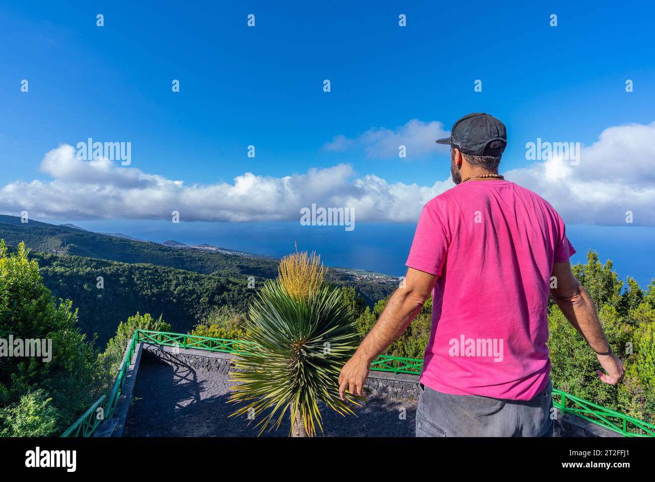 Un jeune homme dans un t-shirt rose au sommet de la montagne au point de vue du parc naturel Cubo de la Galga sur la côte nord-est de l'île de la Banque D'Images