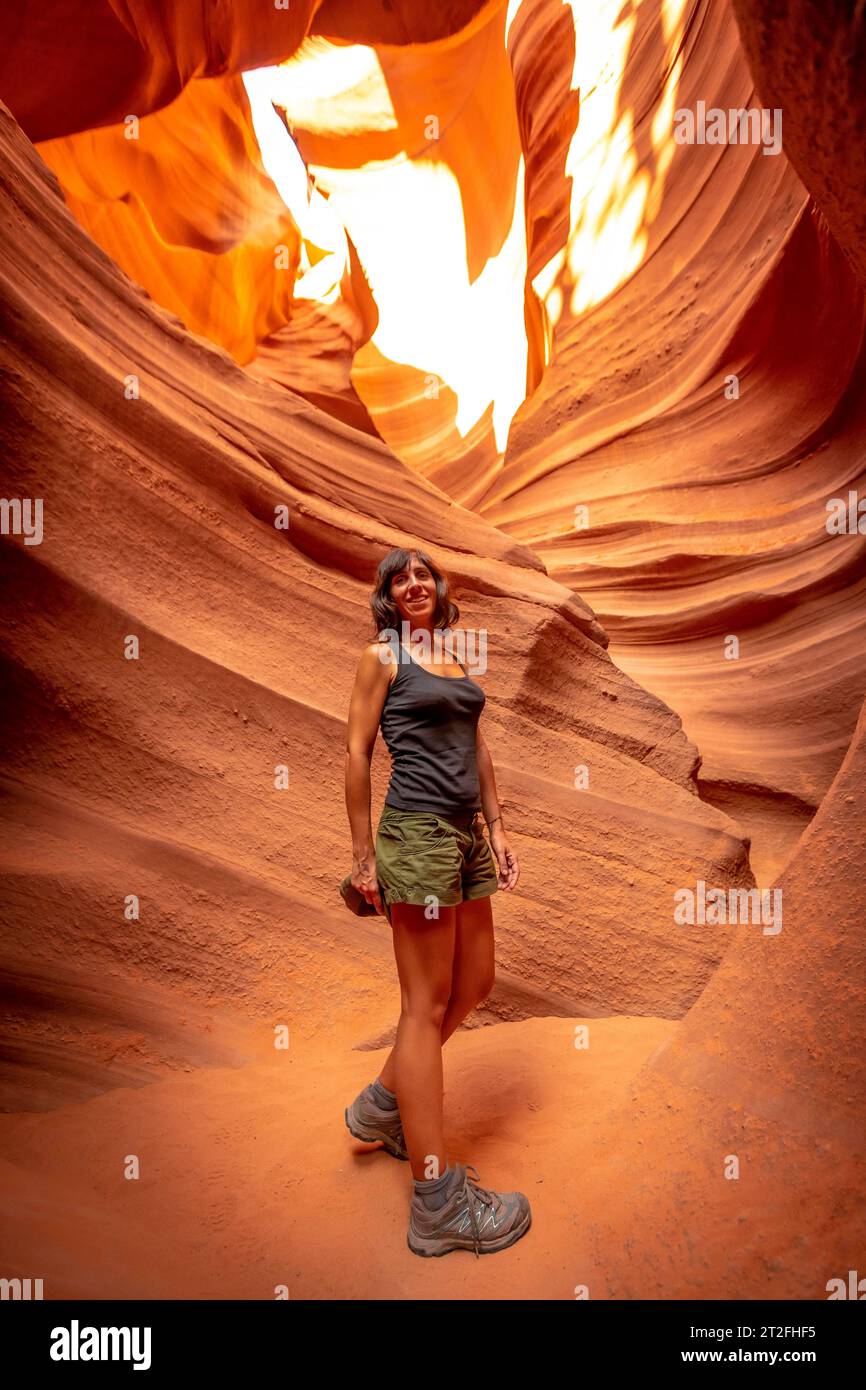 Une jeune femme touriste avec chemise blanche marchant dans Lower Antelope, page, Arizona Banque D'Images