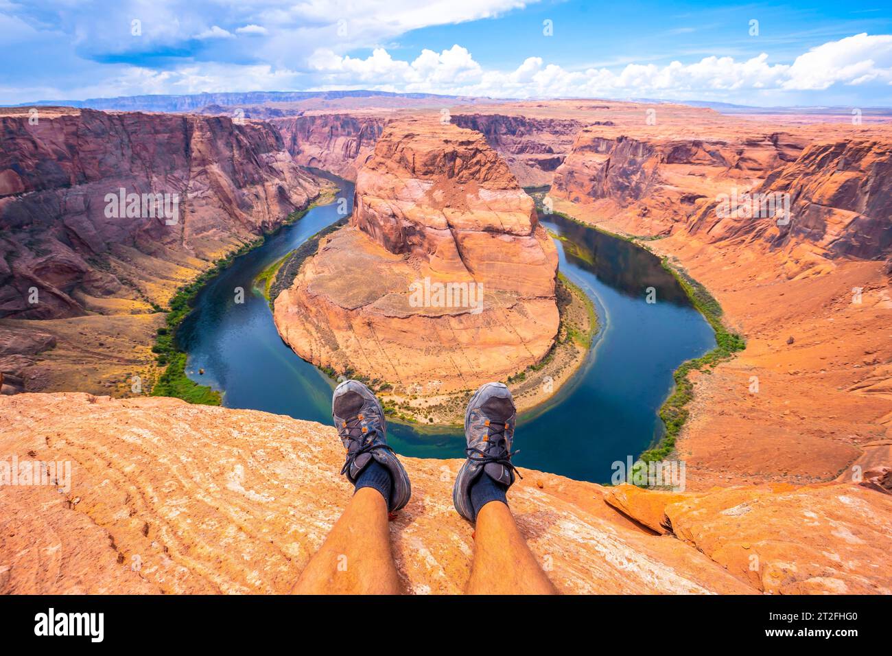 Pieds croisés au repos en regardant Horseshoe Bend et le fleuve Colorado en arrière-plan, Arizona. États-Unis Banque D'Images