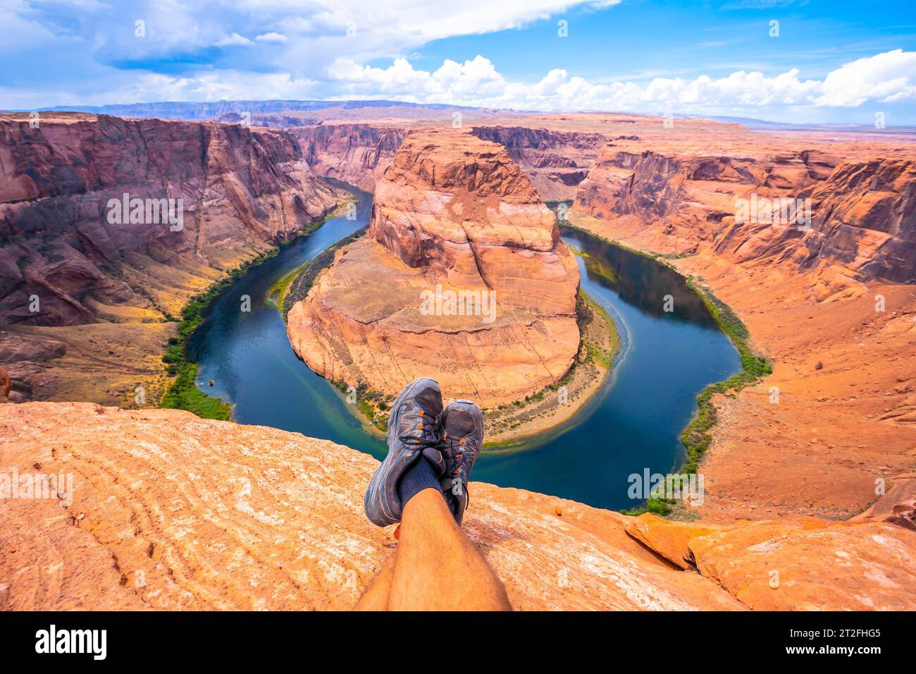 Pieds croisés au repos en regardant Horseshoe Bend et le fleuve Colorado en arrière-plan, Arizona. États-Unis Banque D'Images
