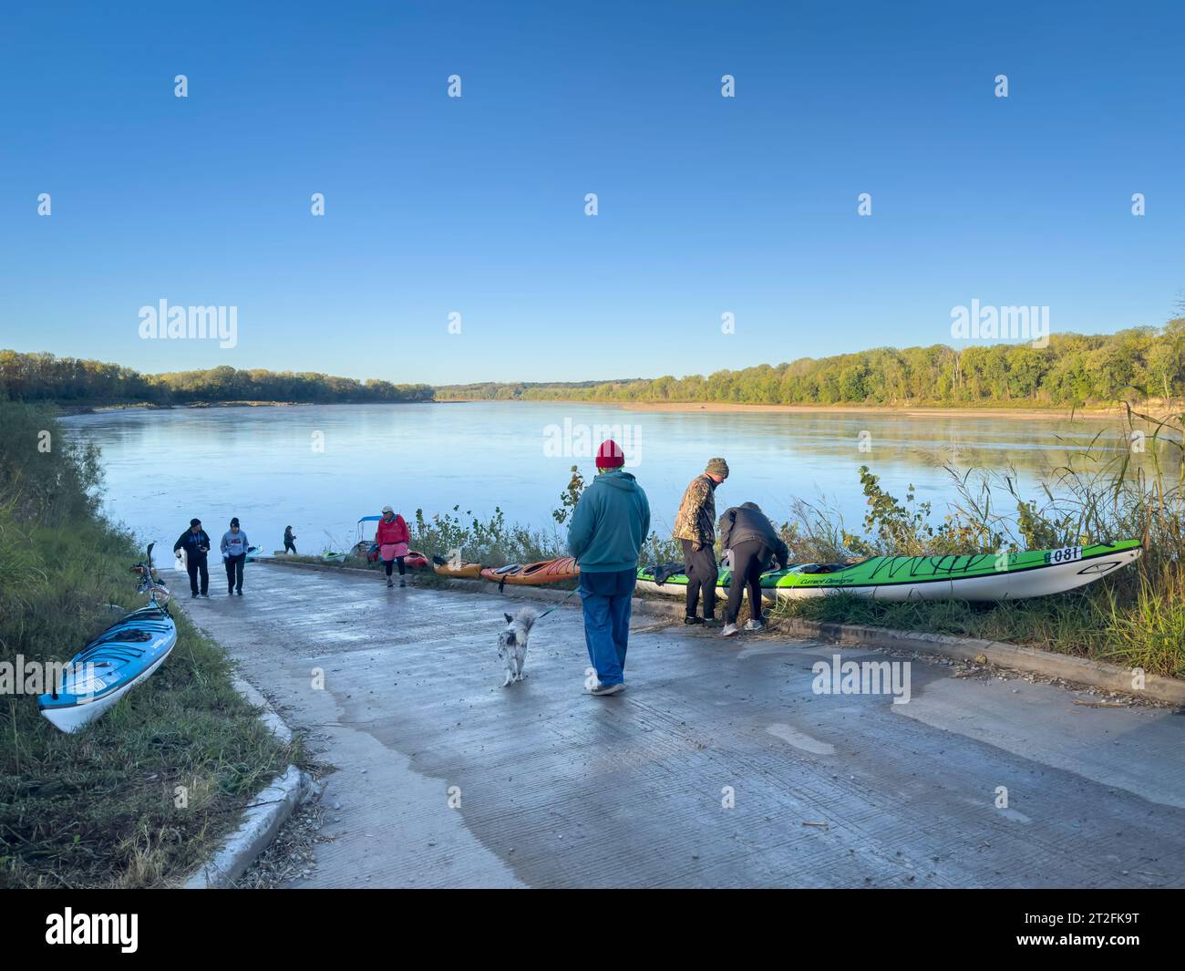 Hartsburg, Mo, États-Unis - 7 octobre 2023 : les pagayeurs préparent des kayaks sur une rampe de bateau au lever du soleil pour lancer un voyage ou une course sur la rivière Missouri. Banque D'Images