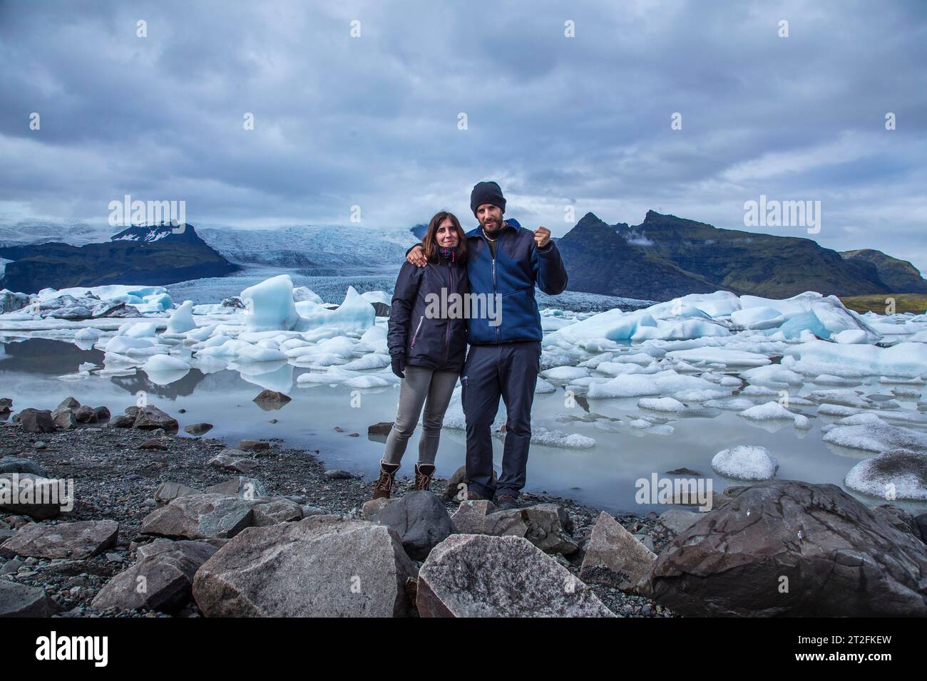 Un couple avec un sac à dos regardant le lac de glace Jokulsarlon dans le cercle doré du sud de l'Islande Banque D'Images
