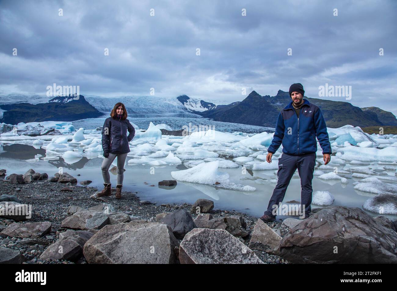 Un couple avec un sac à dos regardant le lac de glace Jokulsarlon dans le cercle doré du sud de l'Islande Banque D'Images