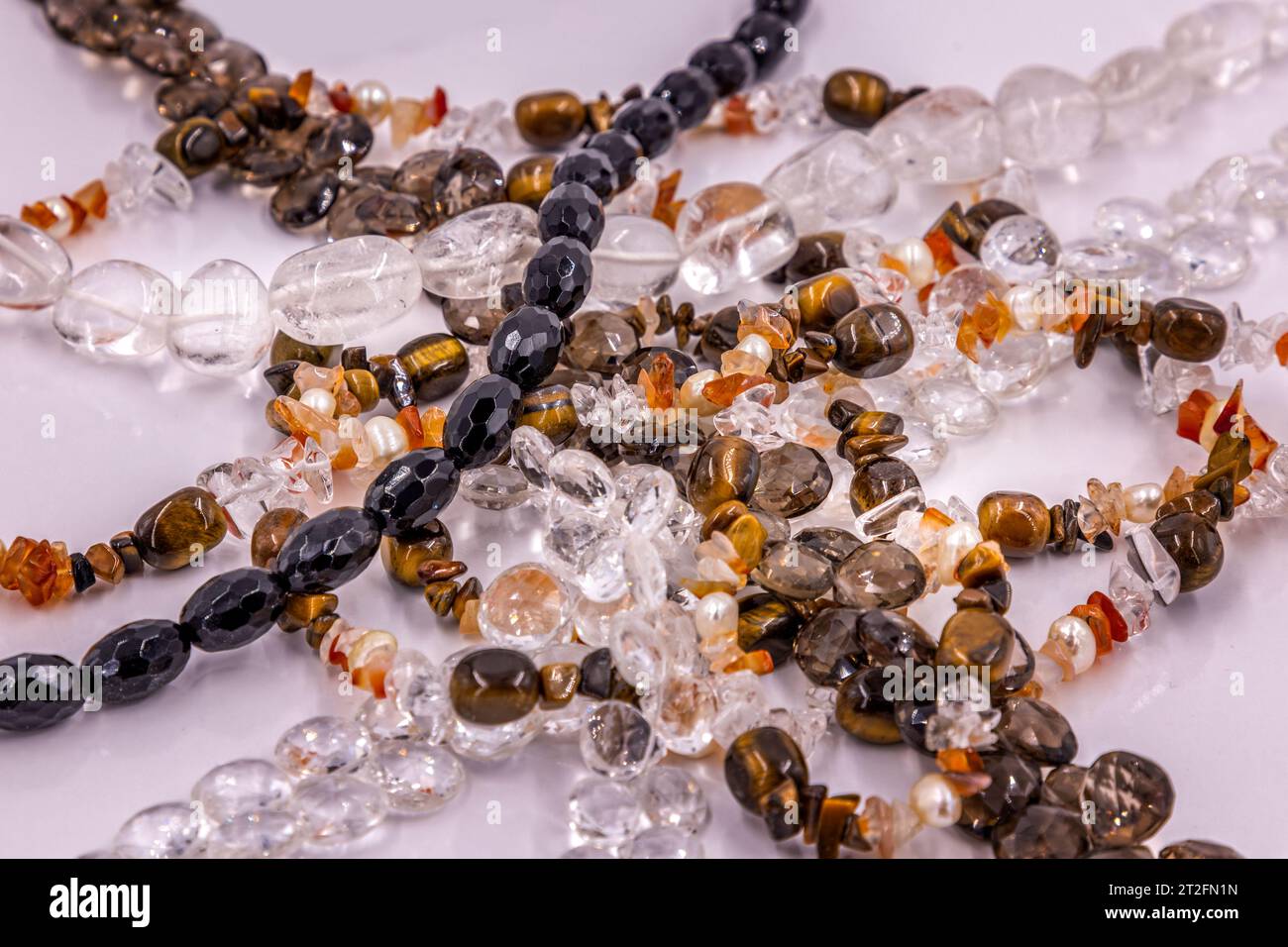 Collection de colliers en pierres semi-précieuses sur une surface blanche Banque D'Images