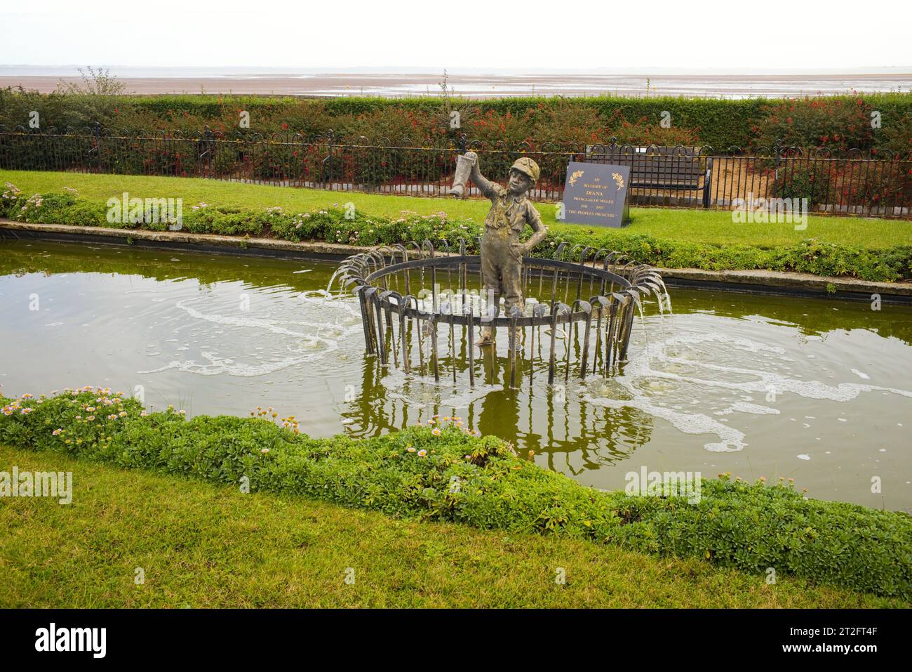 Le garçon avec la fonction d'eau de botte qui fuit à Cleethorpes Banque D'Images