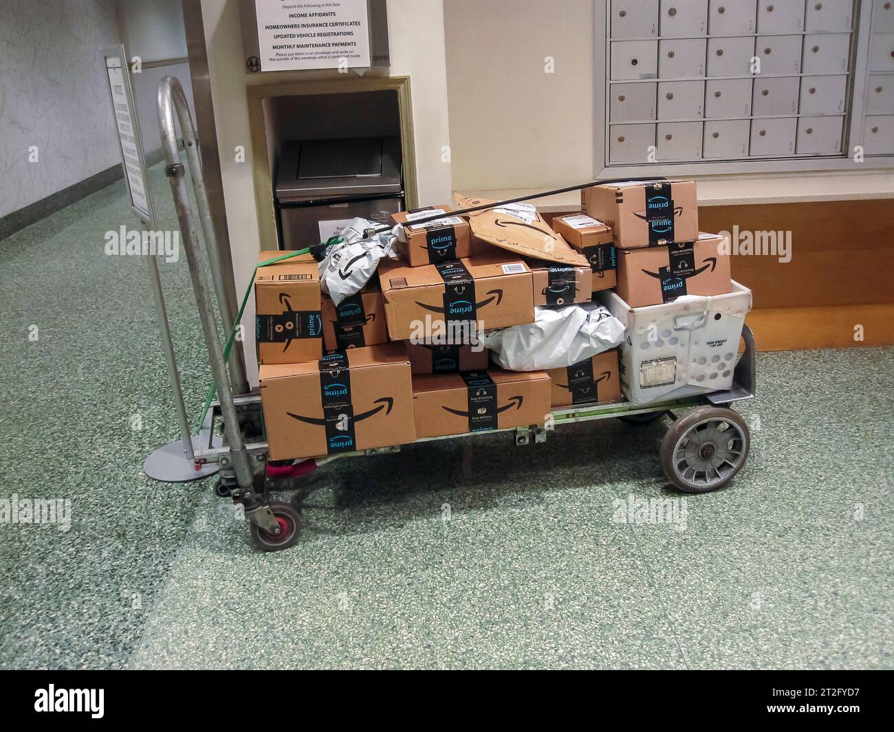 Une charrette chargée de paquets est assise sans surveillance dans le hall d'un immeuble d'appartements du quartier Chelsea de New York le vendredi 13 octobre 2023. (© Richard B. Levine) Banque D'Images