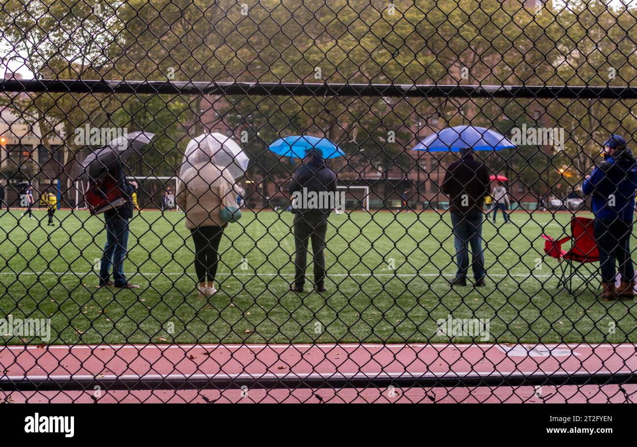 Les parents et les tuteurs regardent la ligue de soccer des jeunes à Chelsea Park à New York sous la pluie le samedi 14 octobre 2023. (© Richard B. Levine) Banque D'Images