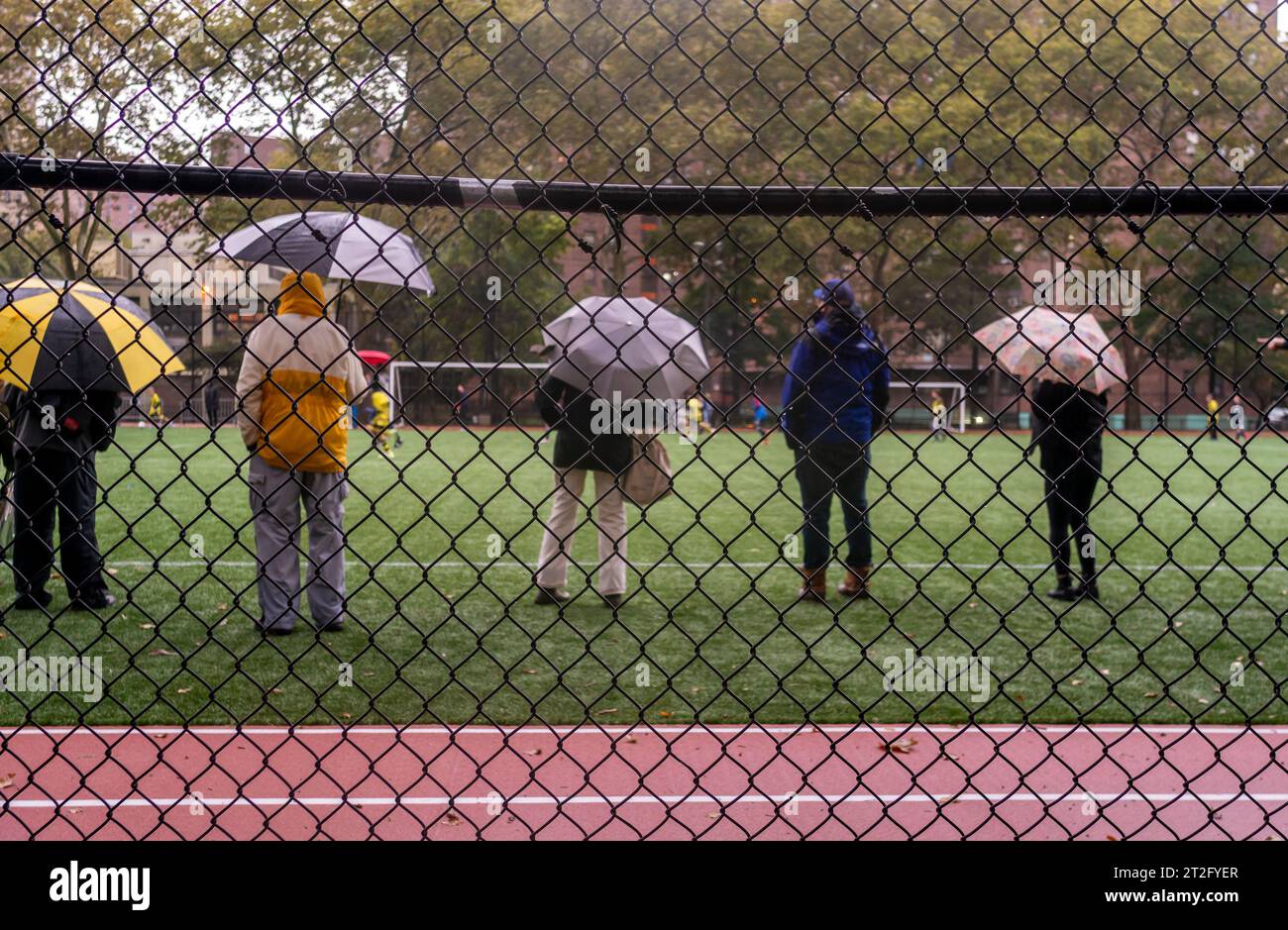 Les parents et les tuteurs regardent la ligue de soccer des jeunes à Chelsea Park à New York sous la pluie le samedi 14 octobre 2023. (© Richard B. Levine) Banque D'Images