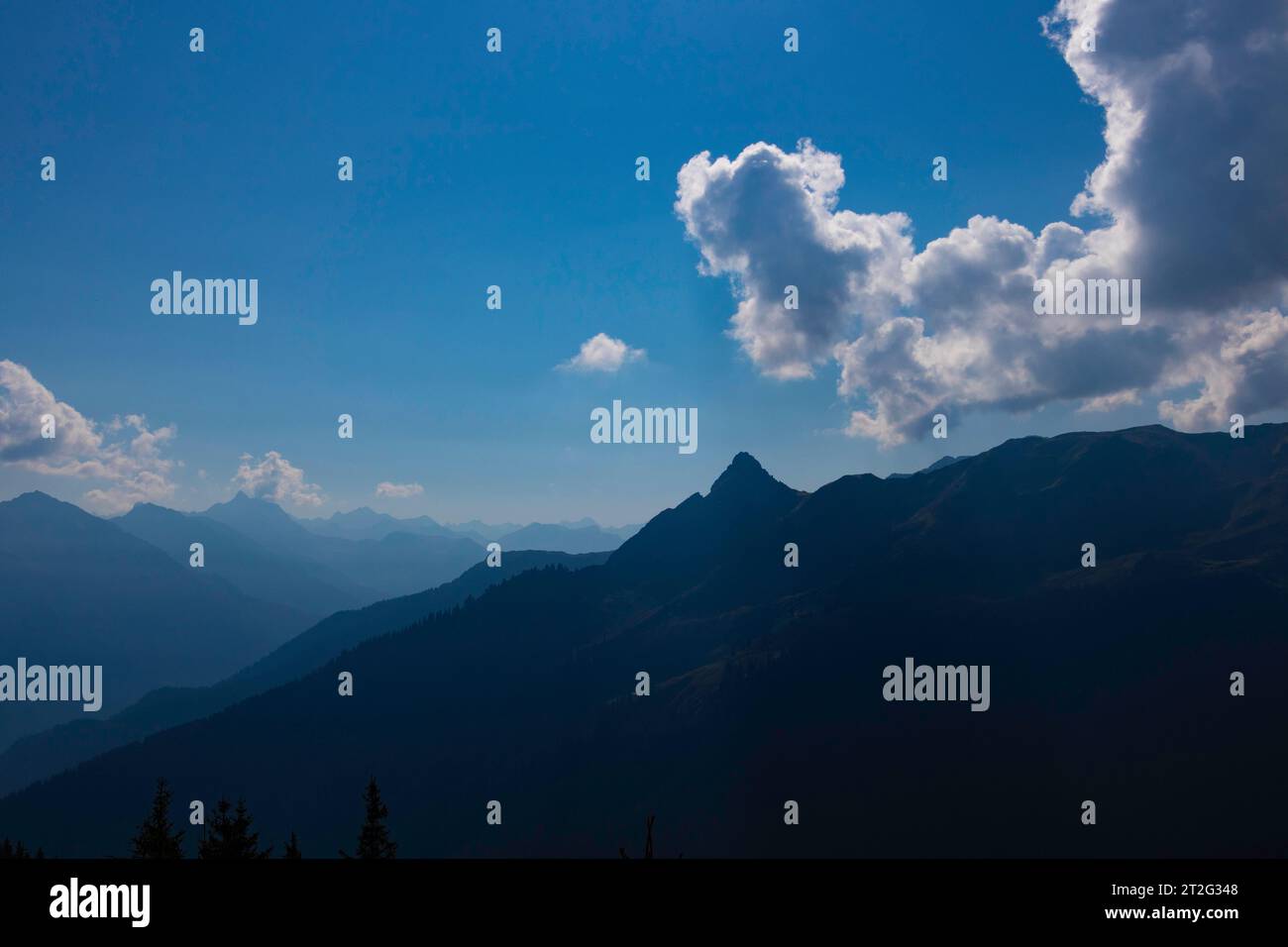 Scène de montagne avec soleil caché derrière les nuages Banque D'Images