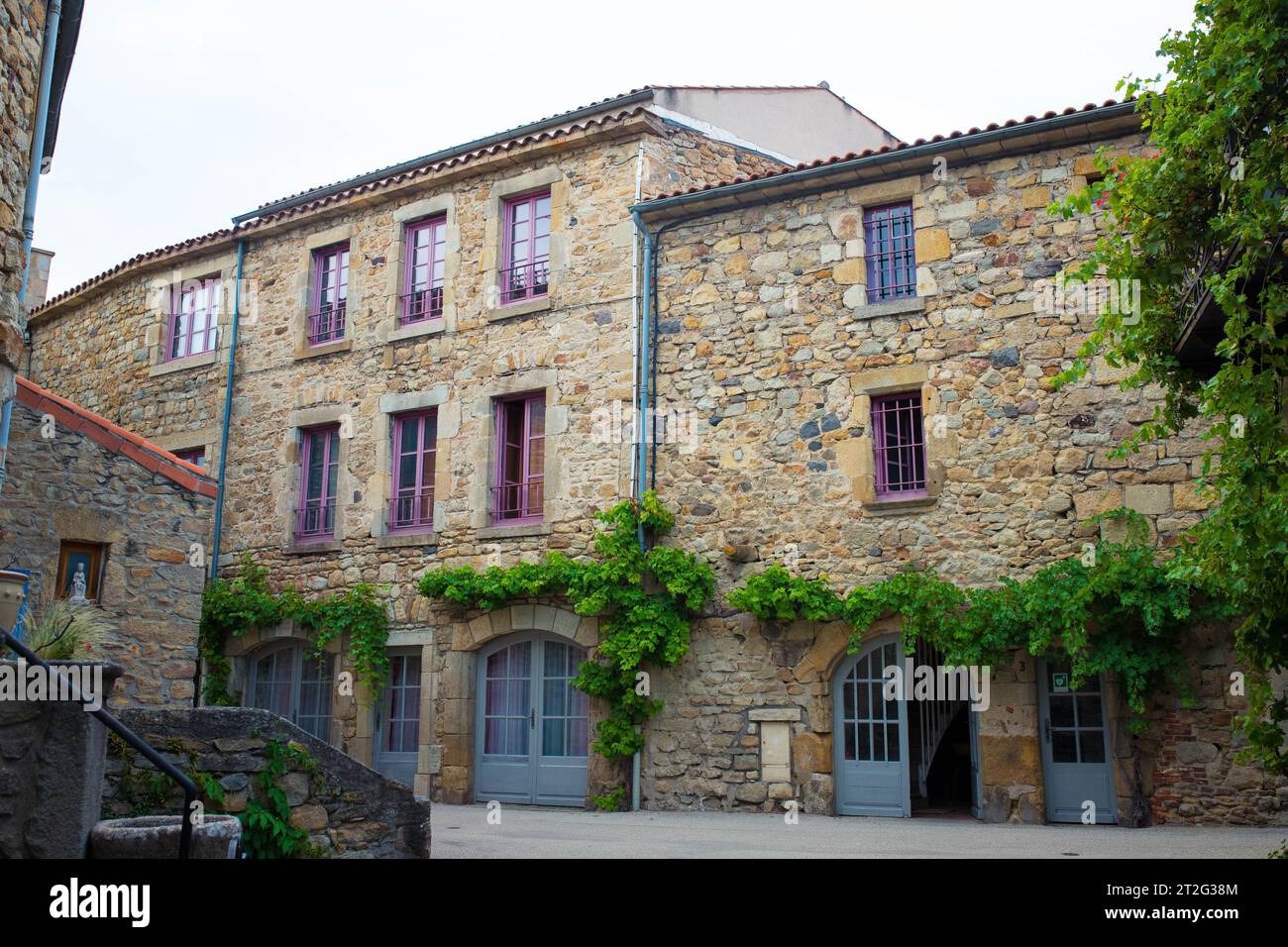 Vue sur la rue avec les bâtiments typiques en pierre dans le charmant village médiéval de Montpeyroux, Auvergne, France. Banque D'Images