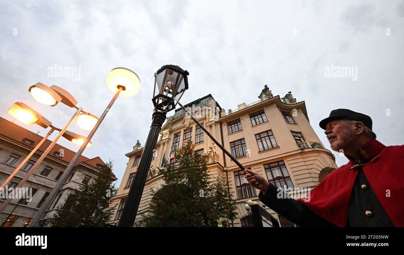 Prague, République tchèque. 19 octobre 2023. Jan Zakovec, directeur du Musée de l'industrie du gaz et président de la Guilde des Lamplighters, vêtu d'un lamplighter, allume une lampe à gaz lors de l'ouverture d'une exposition en plein air pour marquer le 300e anniversaire de l'éclairage public de Prague, sur la place Marian à Prague, en République tchèque, le 19 octobre 2023. Crédit : Michal Kamaryt/CTK photo/Alamy Live News Banque D'Images