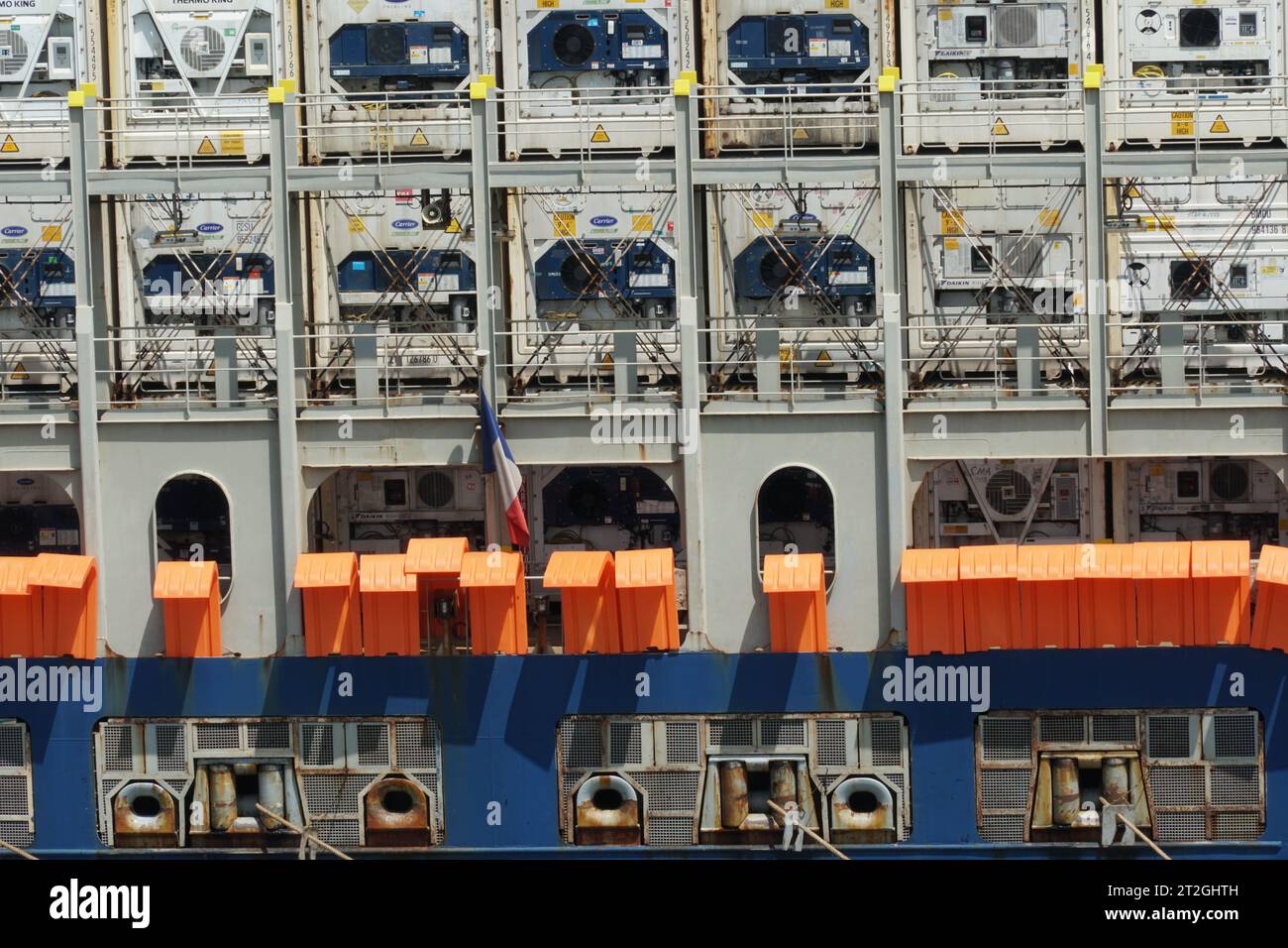 Navire porte-conteneurs avec barrières anti-piratage de couleur orange et treillis métallique et grilles soudés dans toutes les ouvertures dans la partie arrière. Banque D'Images