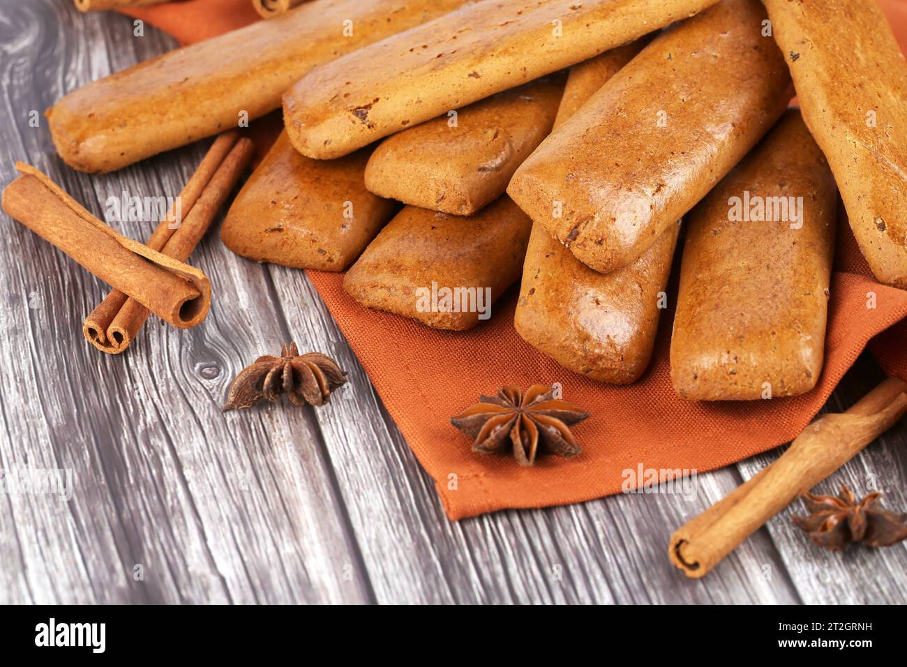 Biscuits avec des bâtons d'anis et de cannelle sur un tissu brun sur une table en bois. Banque D'Images