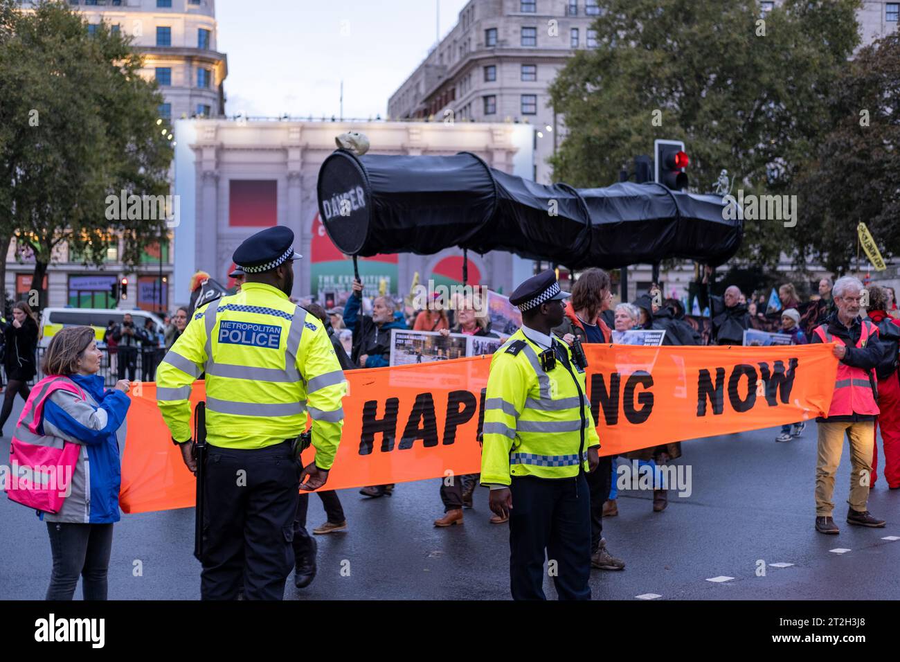 La police surveille les manifestants de Fossil Free London alors qu'ils bloquent la route avec une bannière de protestation à Marble Arch dans le centre de Londres. Octobre 2023. Banque D'Images