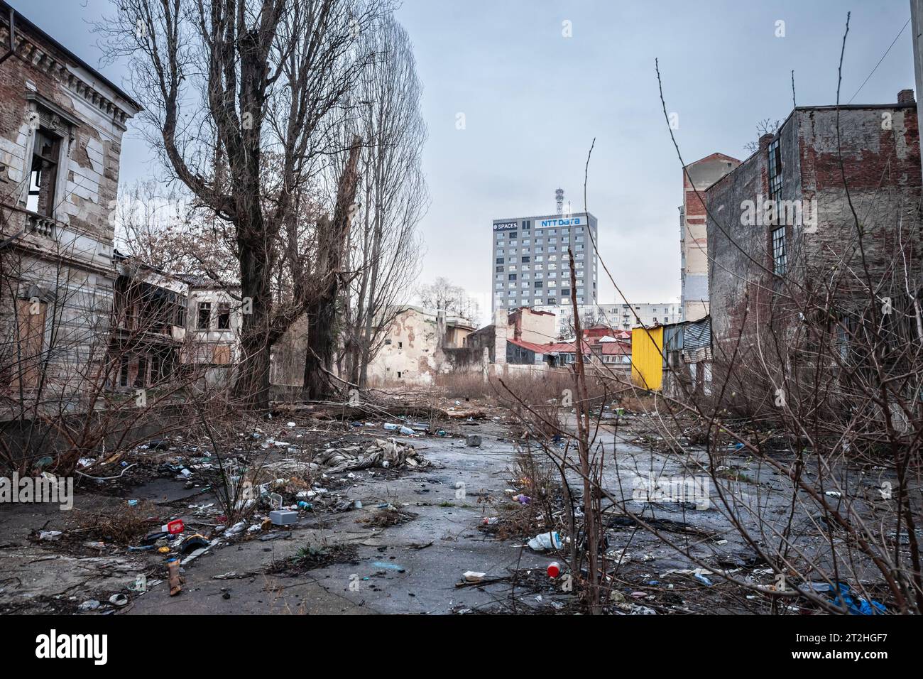 Image d'un gratte-ciel de grande hauteur, bâtiment moderne, en face d'une ancienne junkyard industrielle abandonnée à Bucarest, capitale de la Roumanie. Banque D'Images