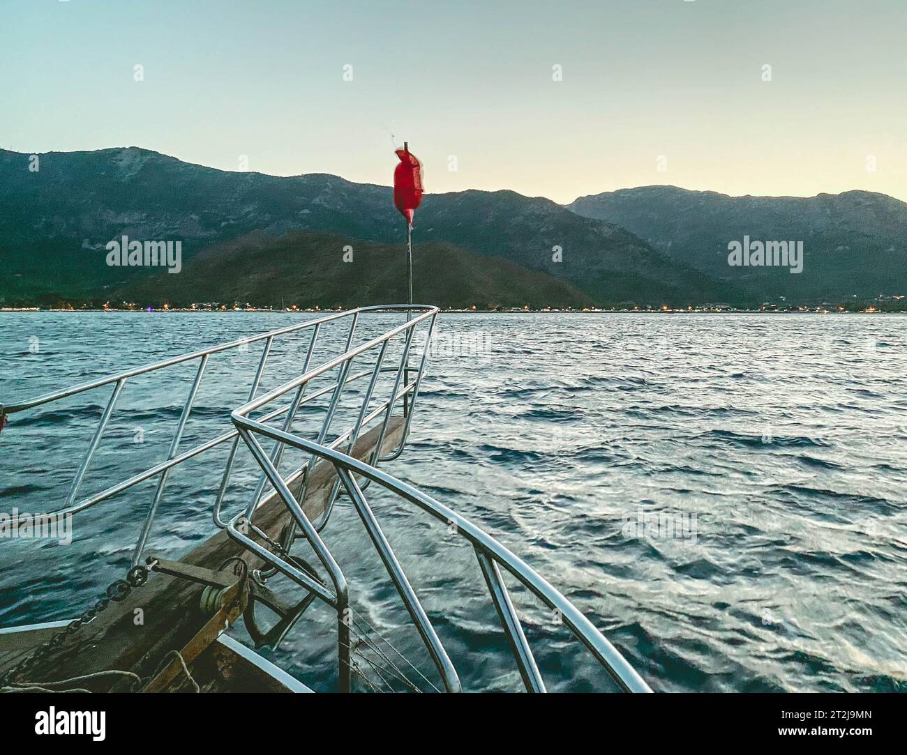 yacht en pleine mer. mer avec une plage de sable sur fond de montagne. le drapeau rouge turc est installé sur la poupe du yacht. Banque D'Images