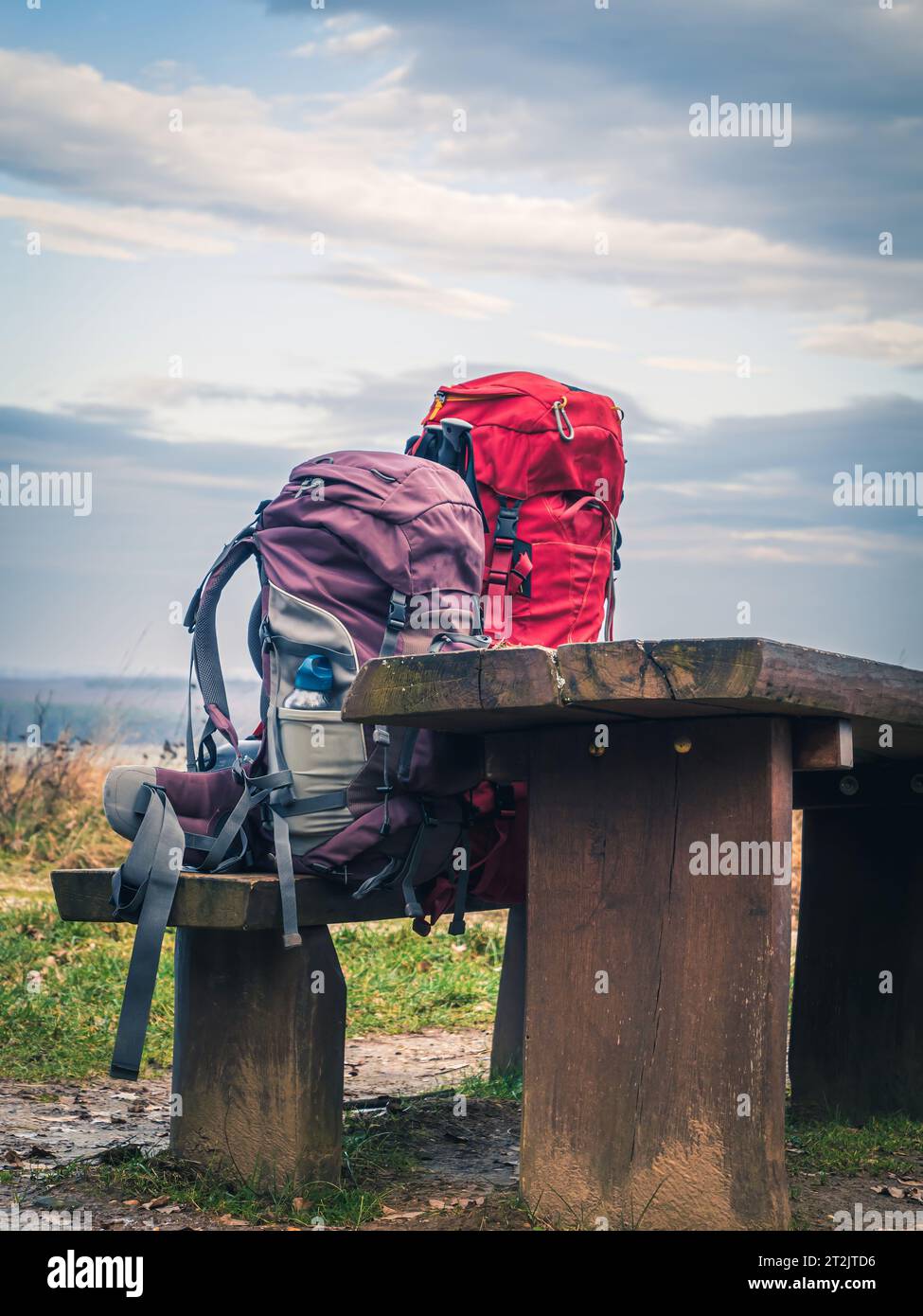 Deux sacs à dos trekking alpinisme randonnée sur un banc en bois rouge violet, pas de gens Banque D'Images