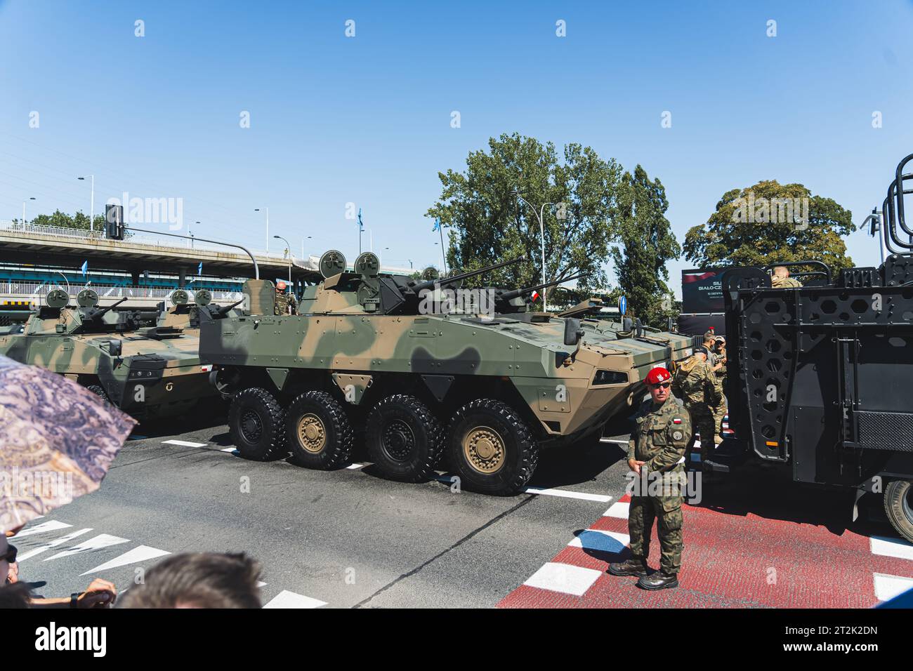 16.08.2023 Varsovie, Pologne. Soldat militaire masculin sérieux concentré en béret rouge gardant le passage des véhicules militaires modernes au cours d'un défilé. Photo de haute qualité Banque D'Images