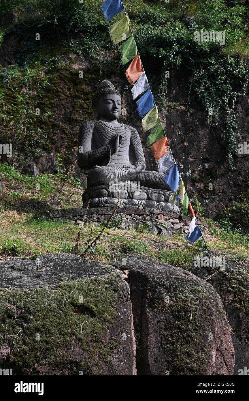 Statue de Bouddha et drapeaux de prière tibétains devant l'entrée du Musée de la montagne Messner près de Bolzano, en Italie Banque D'Images