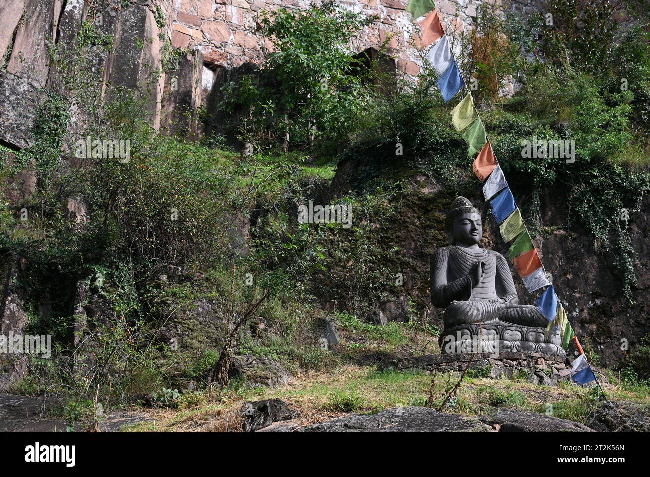 Statue de Bouddha et drapeaux de prière tibétains devant l'entrée du Musée de la montagne Messner près de Bolzano, en Italie Banque D'Images