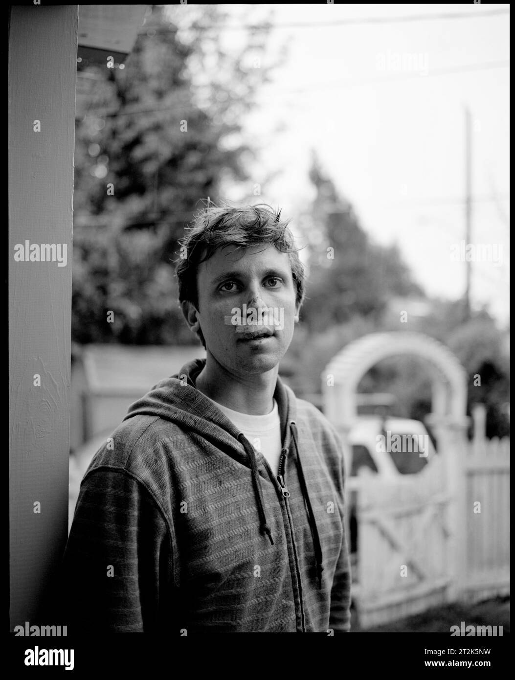 Portrait en noir et blanc d'un jeune homme avec des bandages sur le visage après un accident de vélo. Banque D'Images