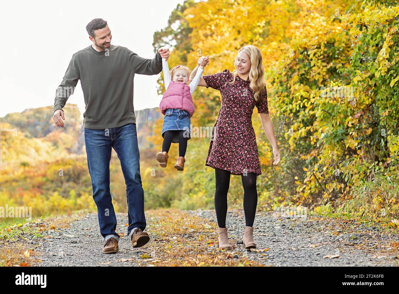 Famille de trois filles qui se balancent dans l'air ; toile de fond d'automne Banque D'Images