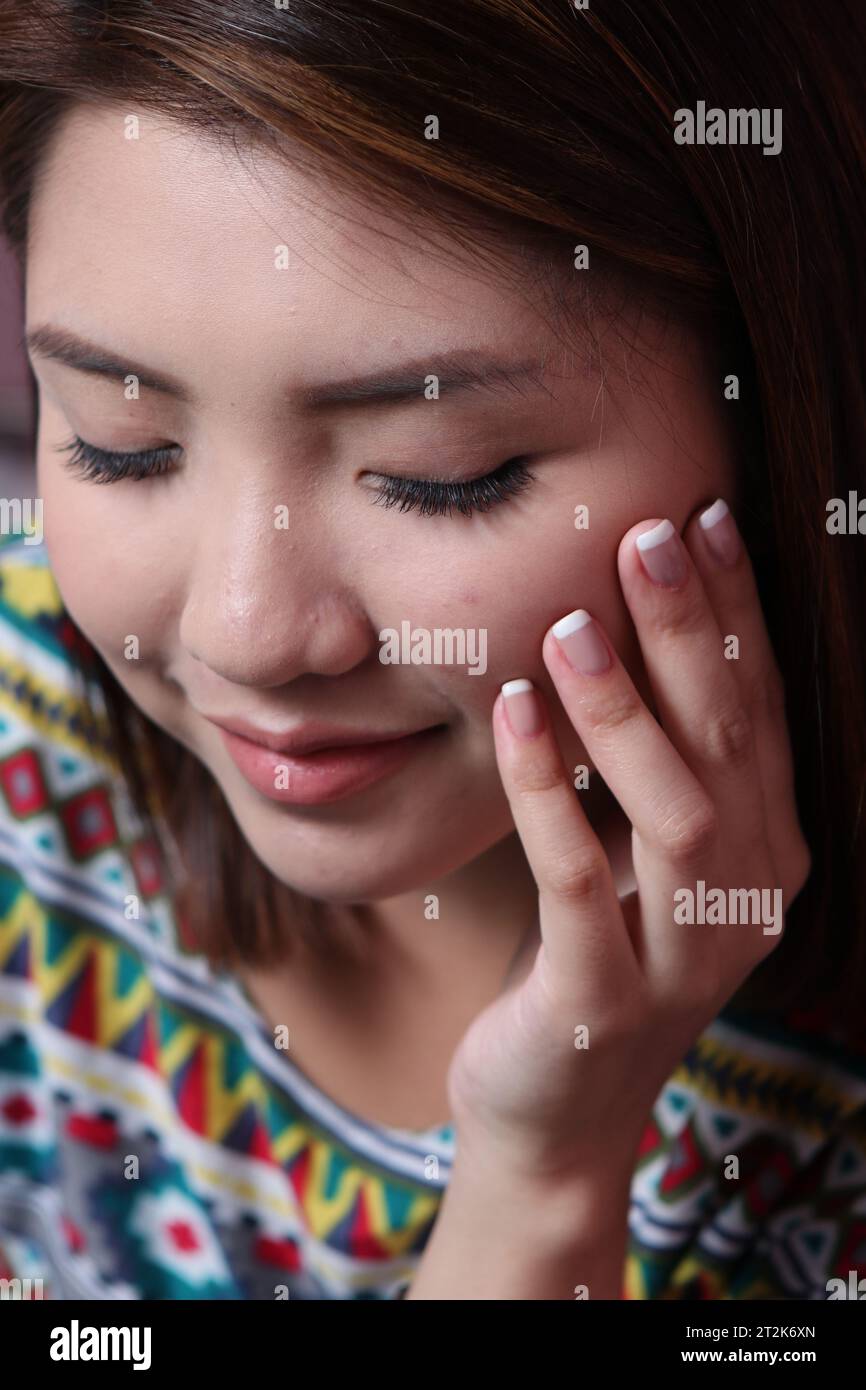 Belle femme asiatique avec de longs cils et des ongles manucurés Banque D'Images