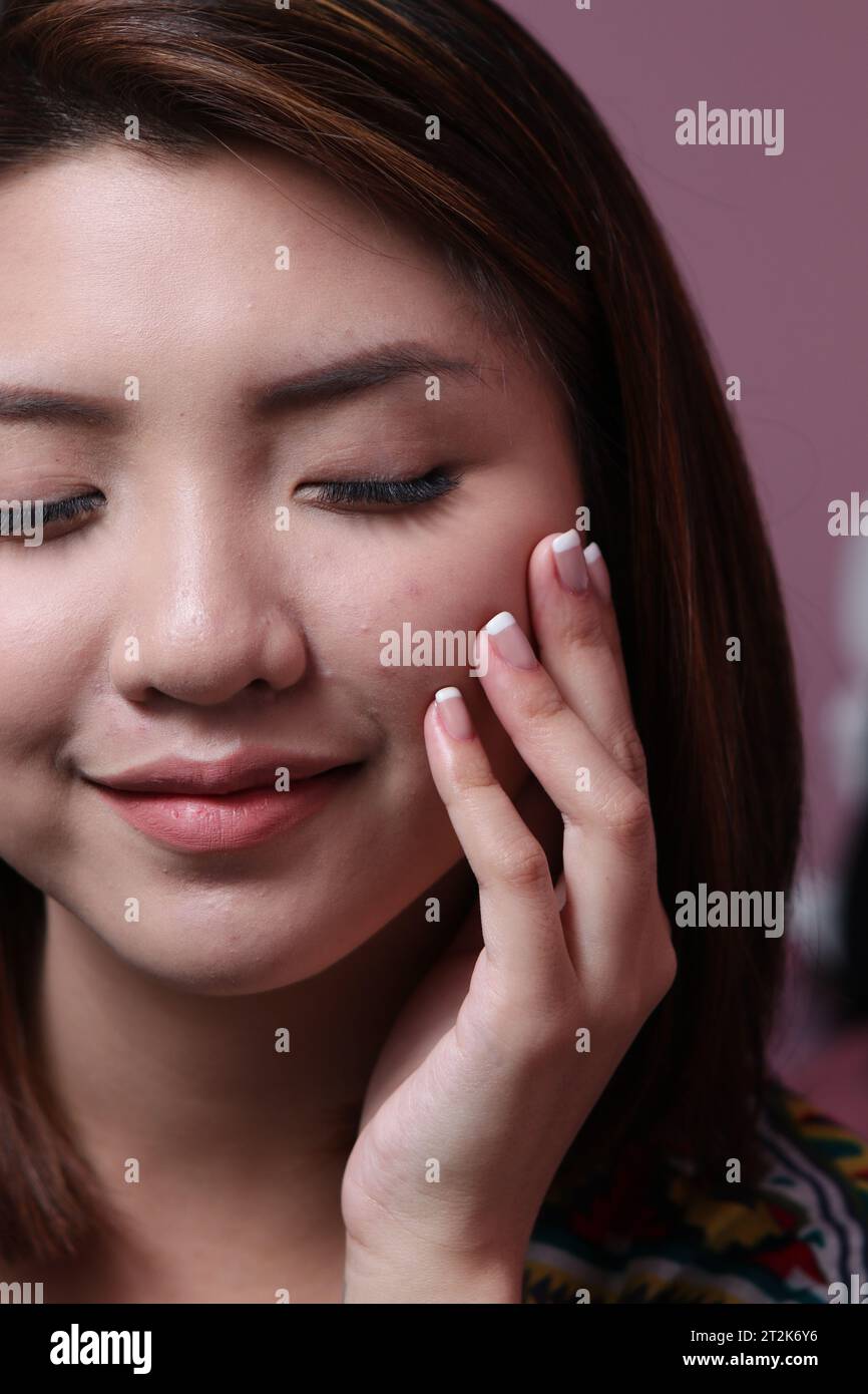 Belle femme asiatique avec de longs cils et des ongles manucurés Banque D'Images