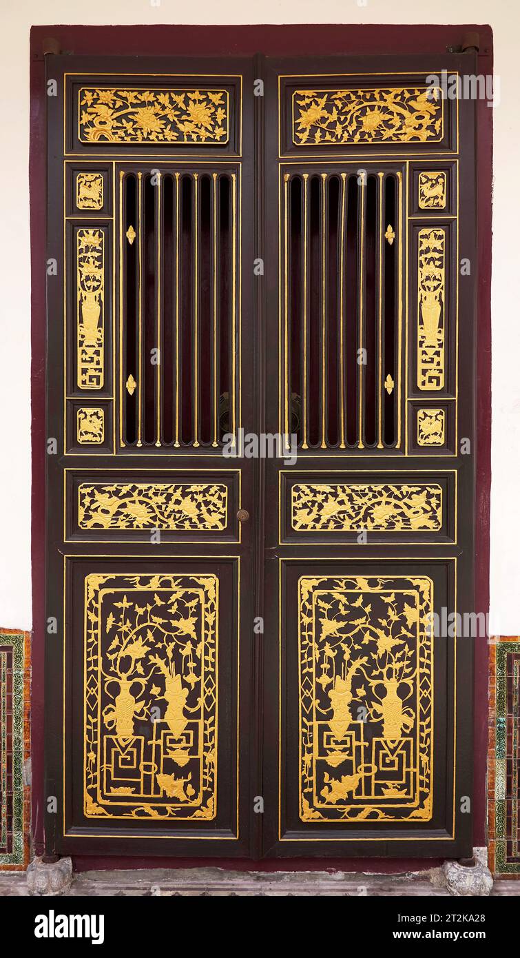 Porte asiatique vintage à Penang. Sculpture en bois de feuille d'or traditionnelle nanyang porte chinoise. Banque D'Images
