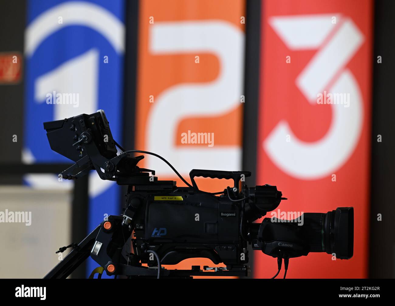 20 octobre 2023, Hesse, Frankfurt/main : les drapeaux avec les logos de la marque ARD (Das Erste, l-r), ZDF (Zweites Deutsches Fernsehen) et 3Rors sont vus en arrière-plan d'une caméra de télévision à la Foire du livre de Francfort. Photo : Arne Dedert/dpa Banque D'Images