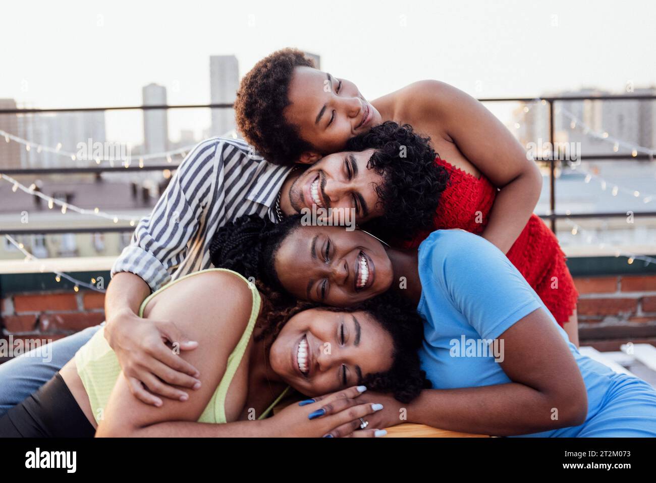 Quatre amis multiethniques se mettent la tête sur les autres. Des jeunes de race mixte dans le contexte d'une grande ville. Mignonnes filles africaines et un Banque D'Images