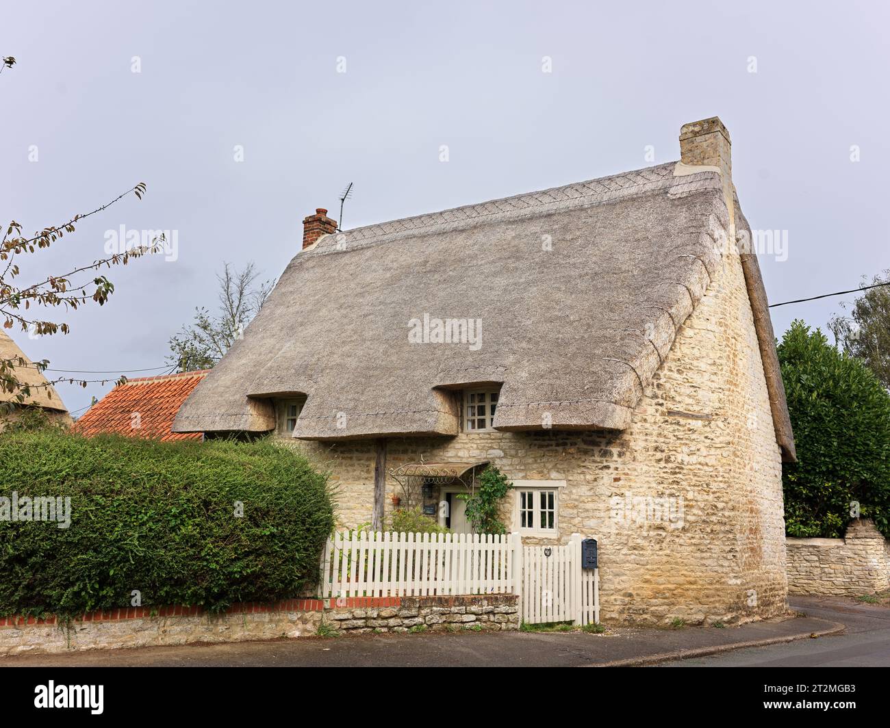 Une maison en pierre au toit de chaume dans le village anglais de Wadenhoe, Northamptonshire, Angleterre. Banque D'Images